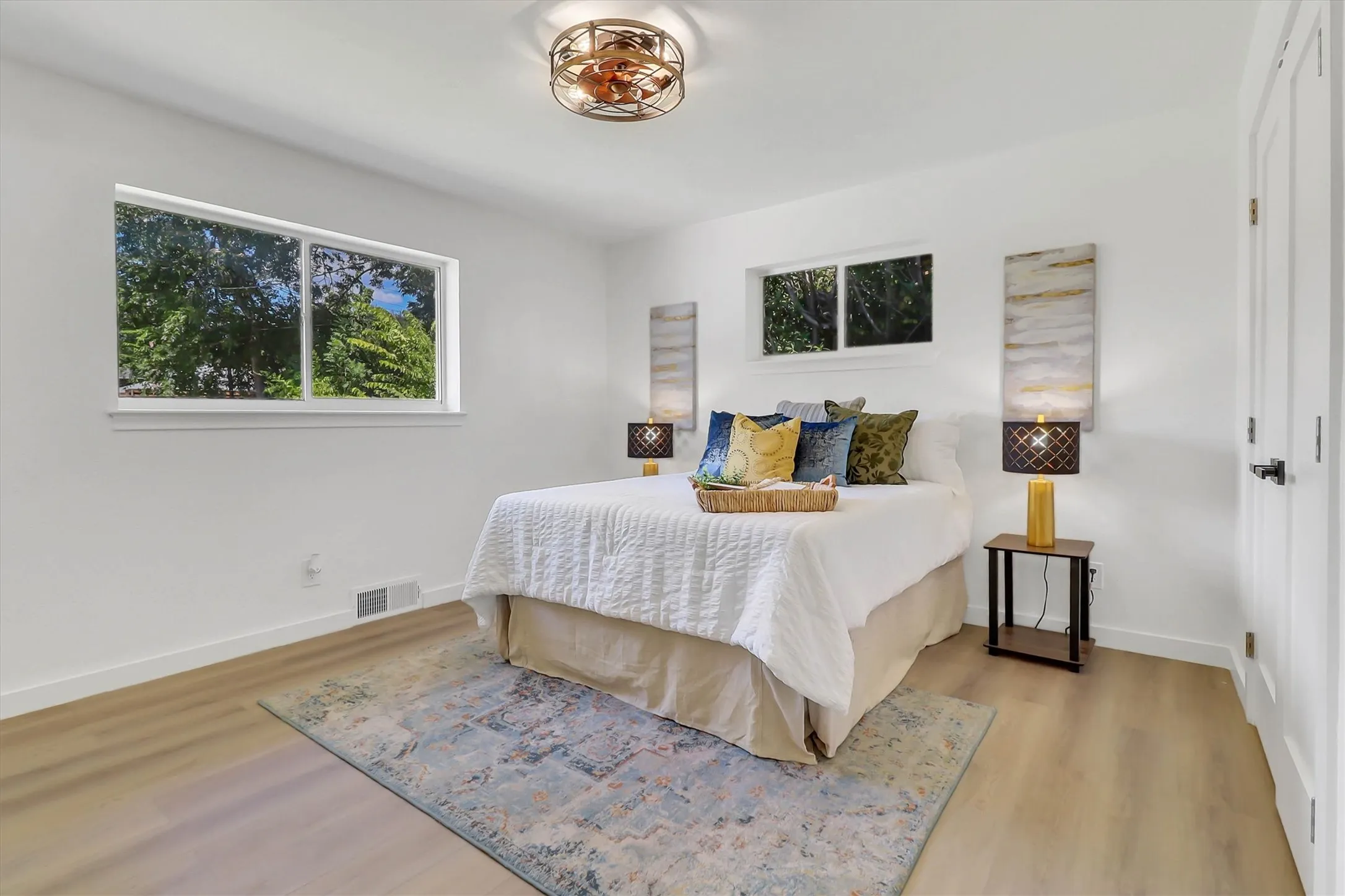 Light wood-finish flooring, white walls, and a multi-pane window