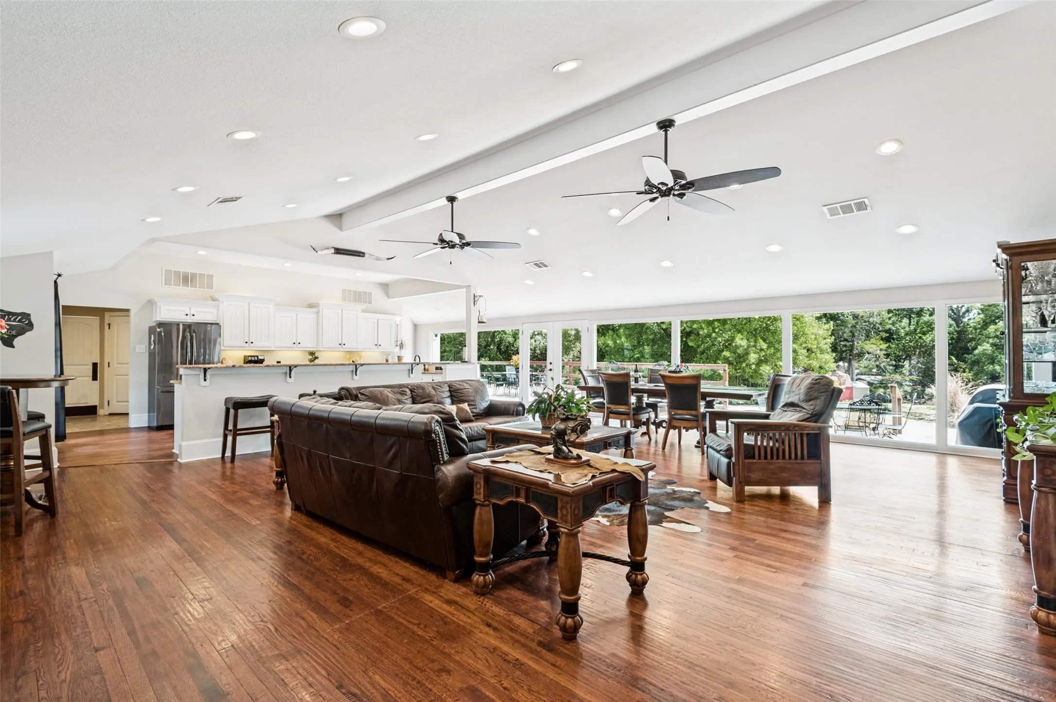 Open-concept living area featuring wood-finish flooring, recessed lighting, and expansive windows