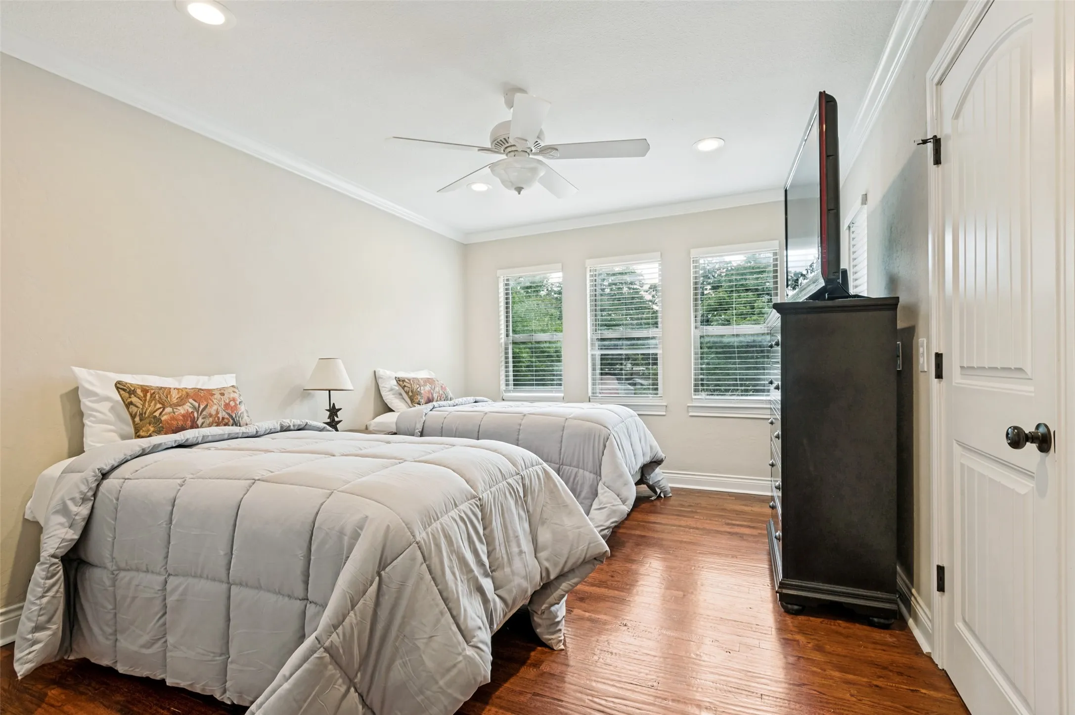 Hardwood flooring, triple windows with blinds, recessed lighting, ceiling fan, and white crown molding