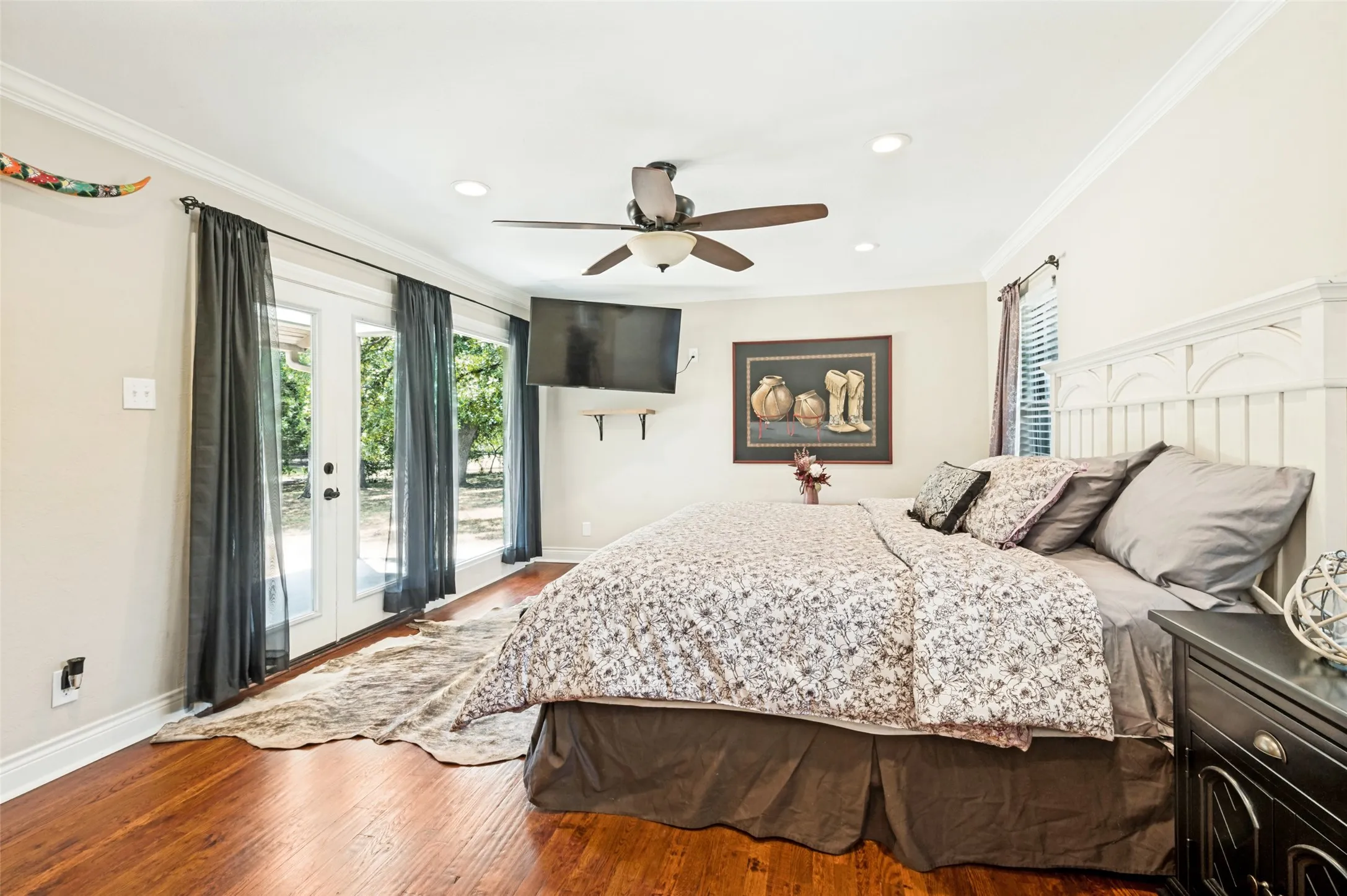 Hardwood flooring, crown molding, ceiling fan, recessed lighting, and double French doors