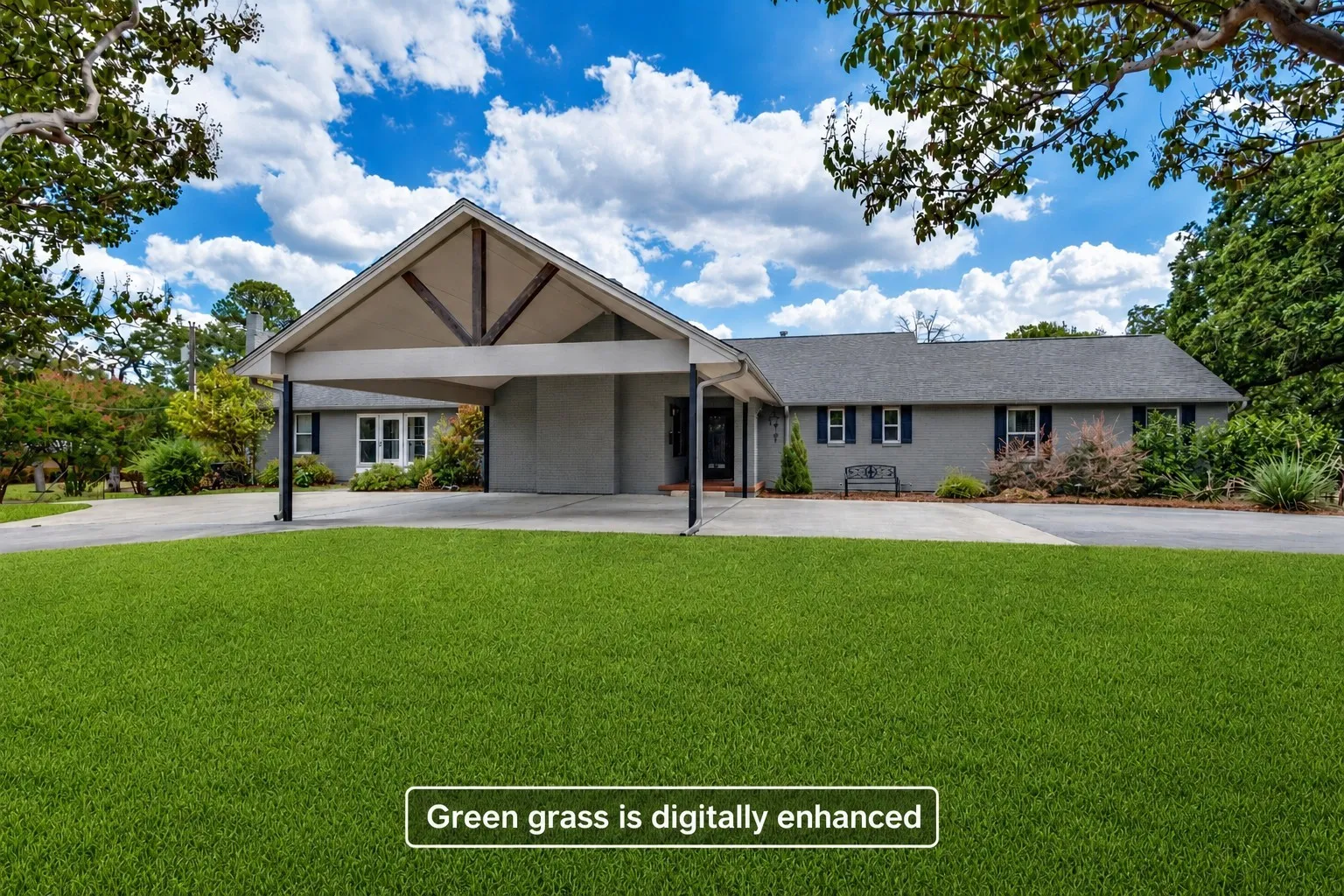 Single-story residence featuring a covered carport with exposed wood beams, a paved driveway, and mature trees