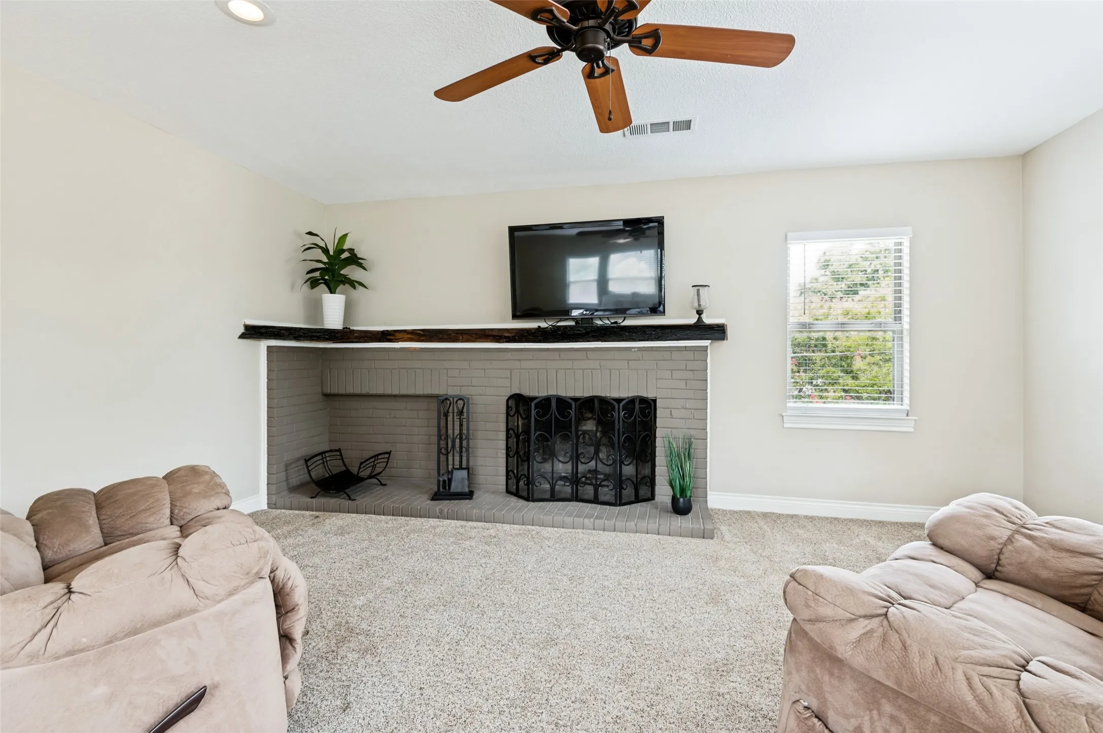 2nd primary sitting area with fireplace with a wood mantle, recessed lighting, ceiling fan, and window with blinds