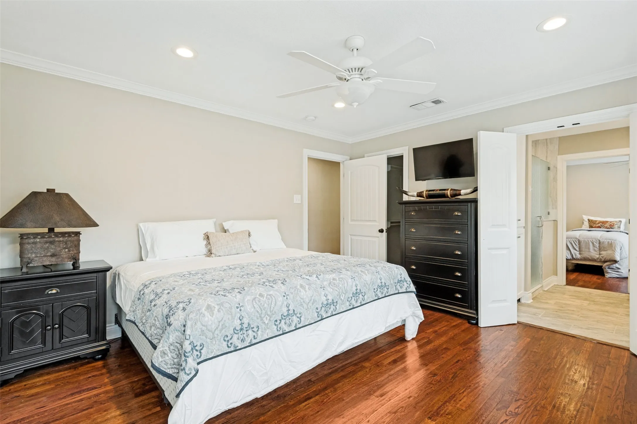 Hardwood-style flooring throughout, crown molding, recessed lighting, and a ceiling fan with integrated lighting