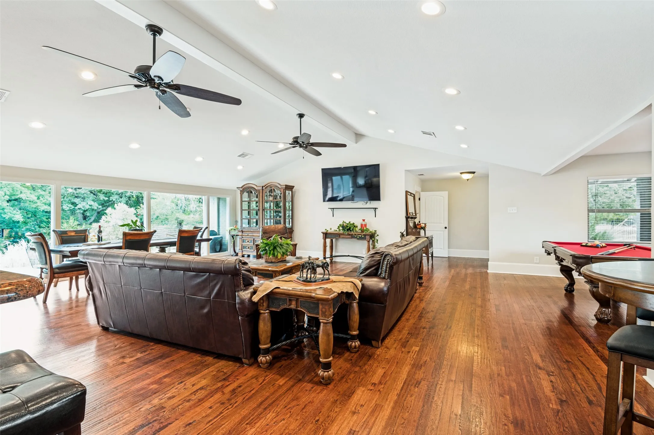 Hardwood flooring throughout, recessed lighting, vaulted ceiling, expansive window wall, and ceiling fans