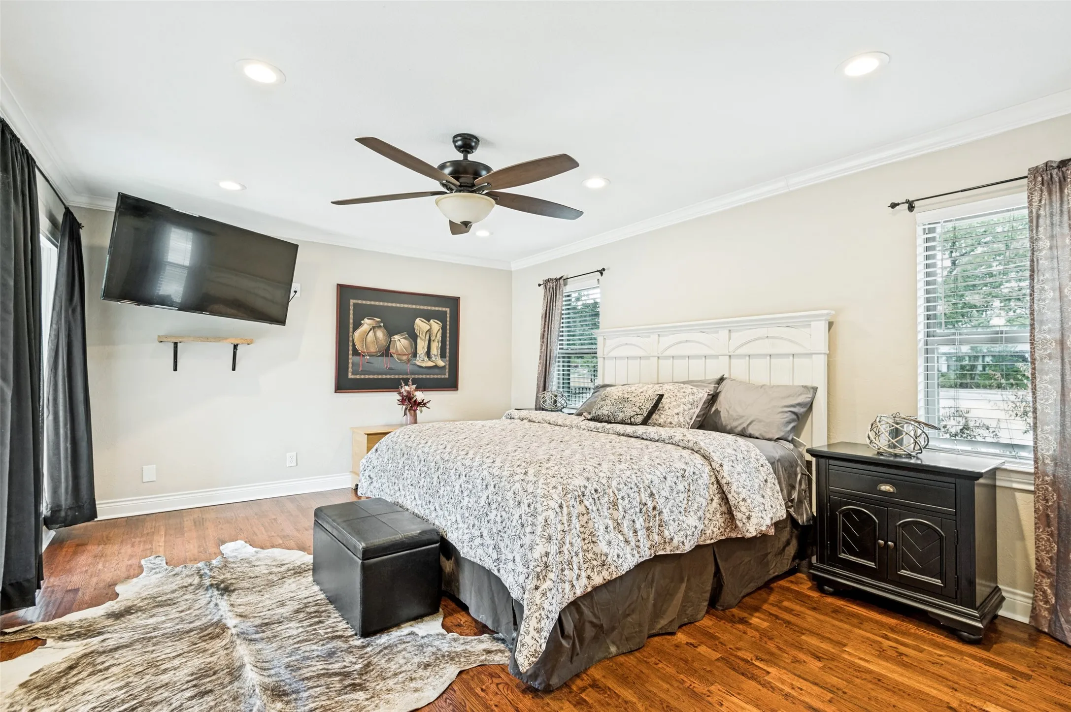 Warm wood-finish flooring, recessed lighting, and a ceiling fan with integrated lighting