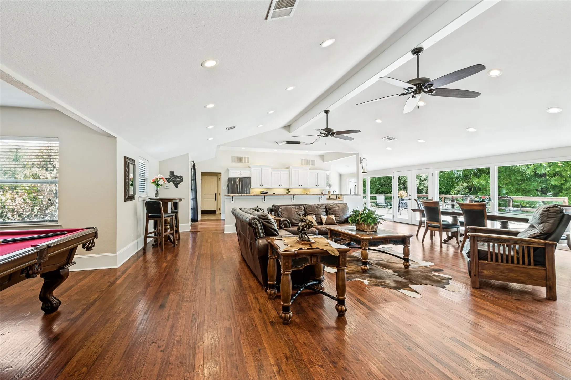 Hardwood flooring throughout, recessed lighting, ceiling fans, and a wall of windows