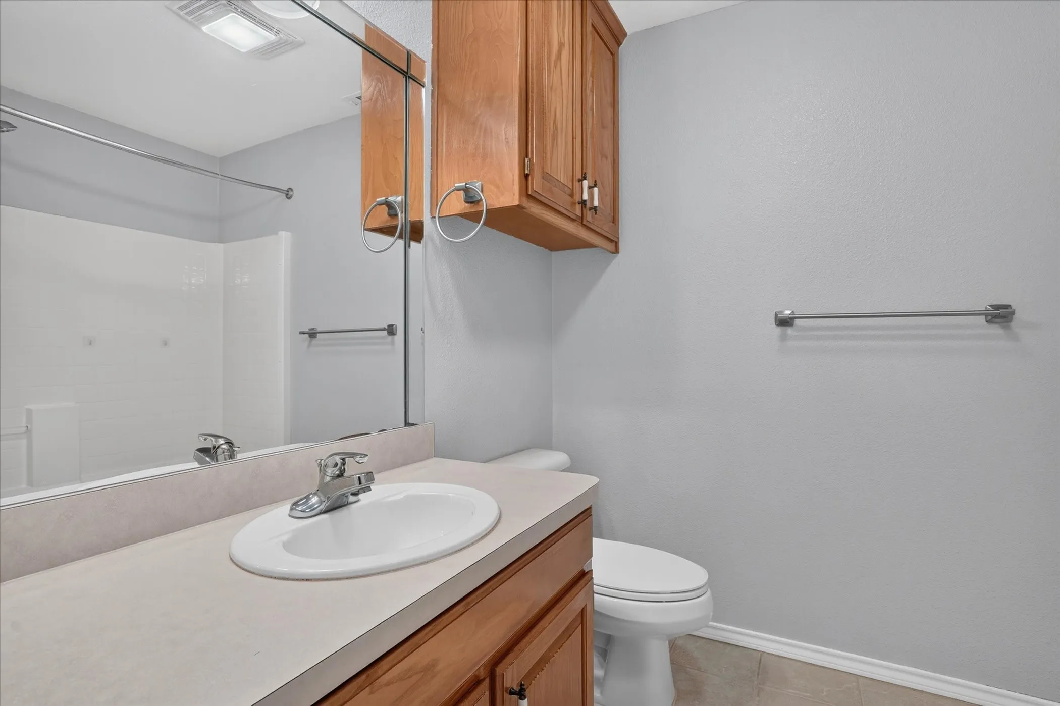 Wood-finish vanity with an integrated sink and chrome faucet