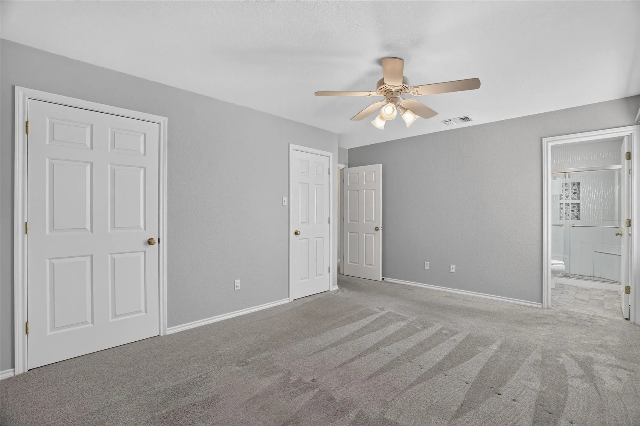 Neutral wall color, carpet flooring, ceiling fan, and six-panel doors