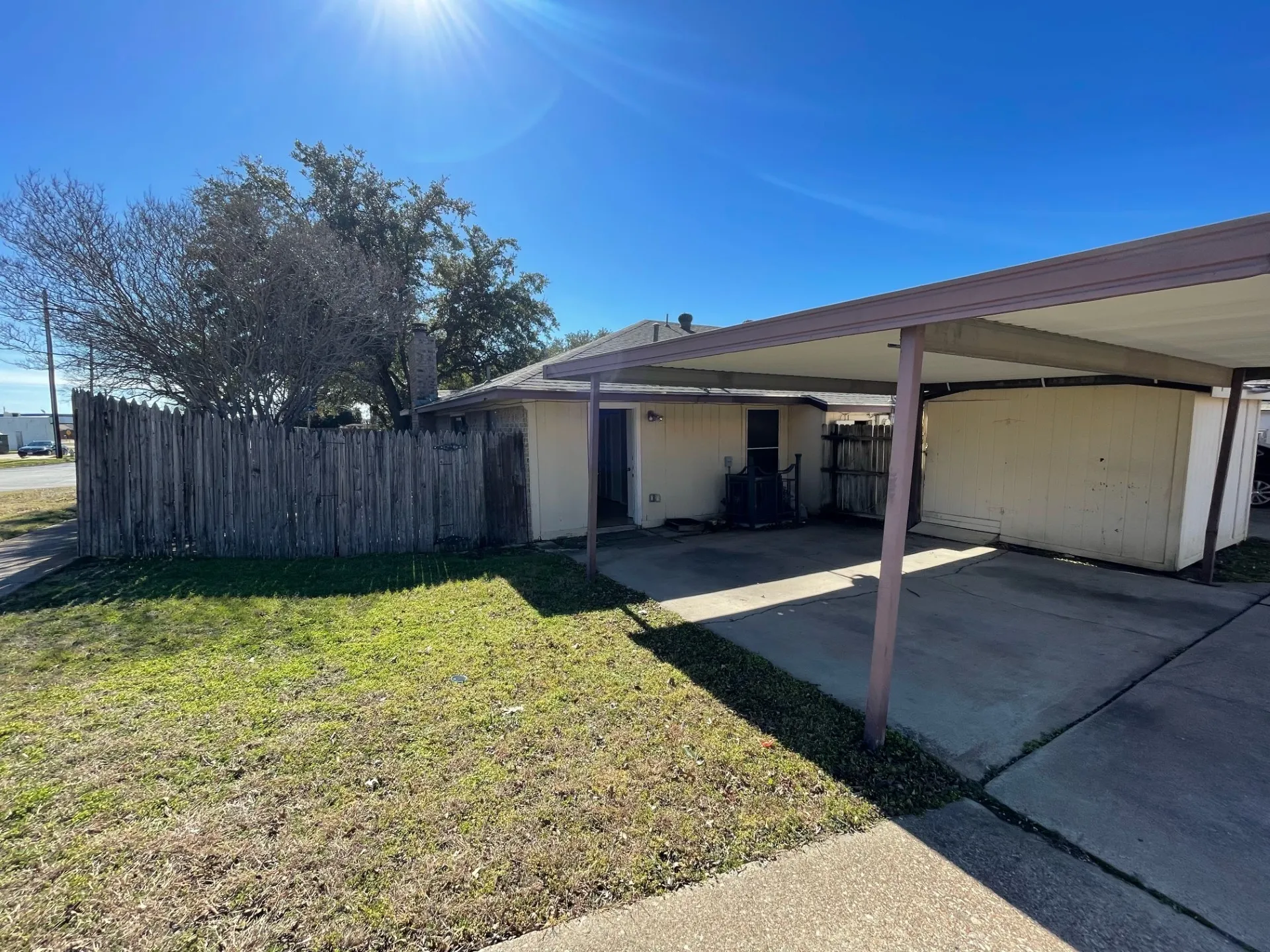 View of side of property with an attached carport and driveway