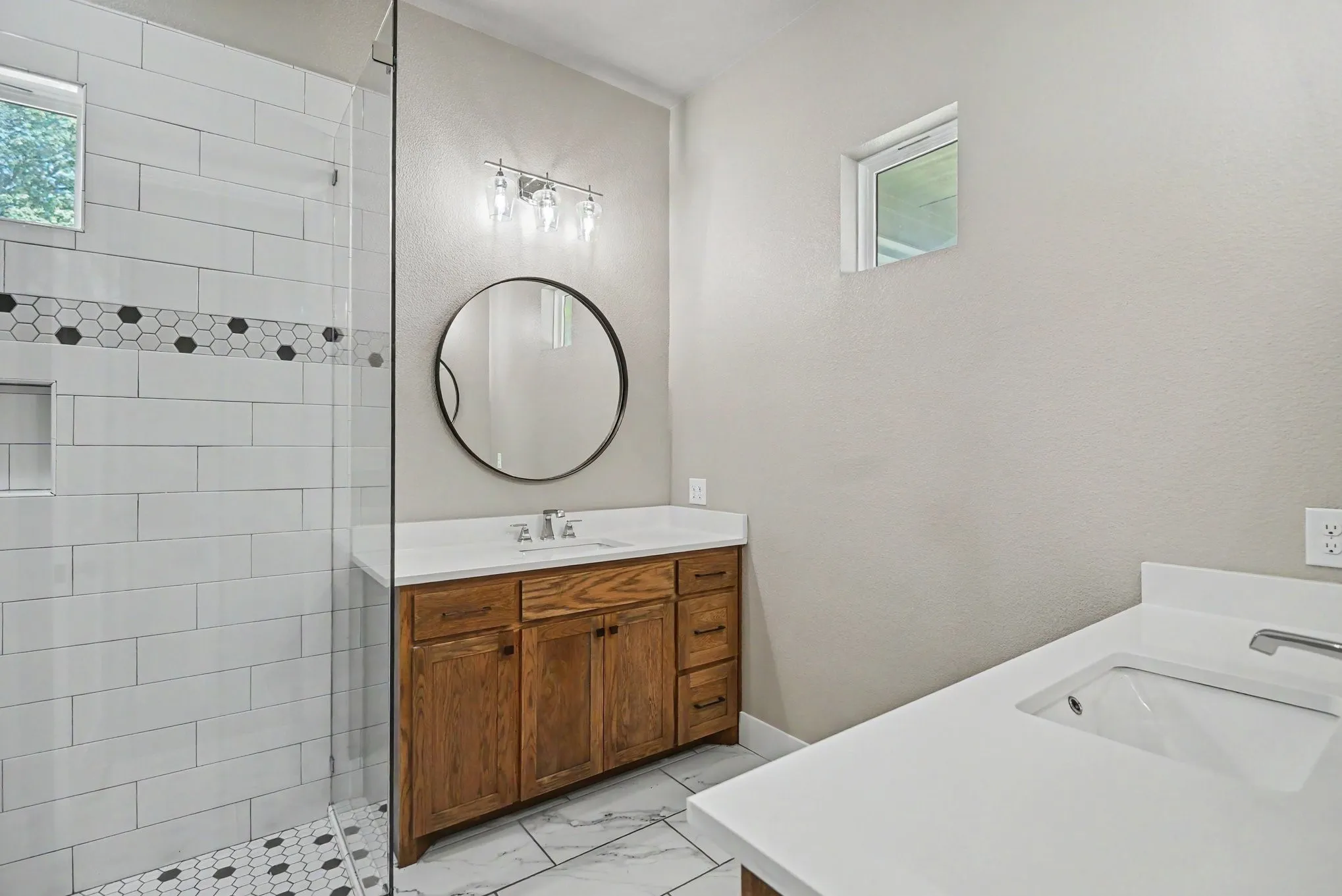 Primary bathroom features split vanities and beautiful shower