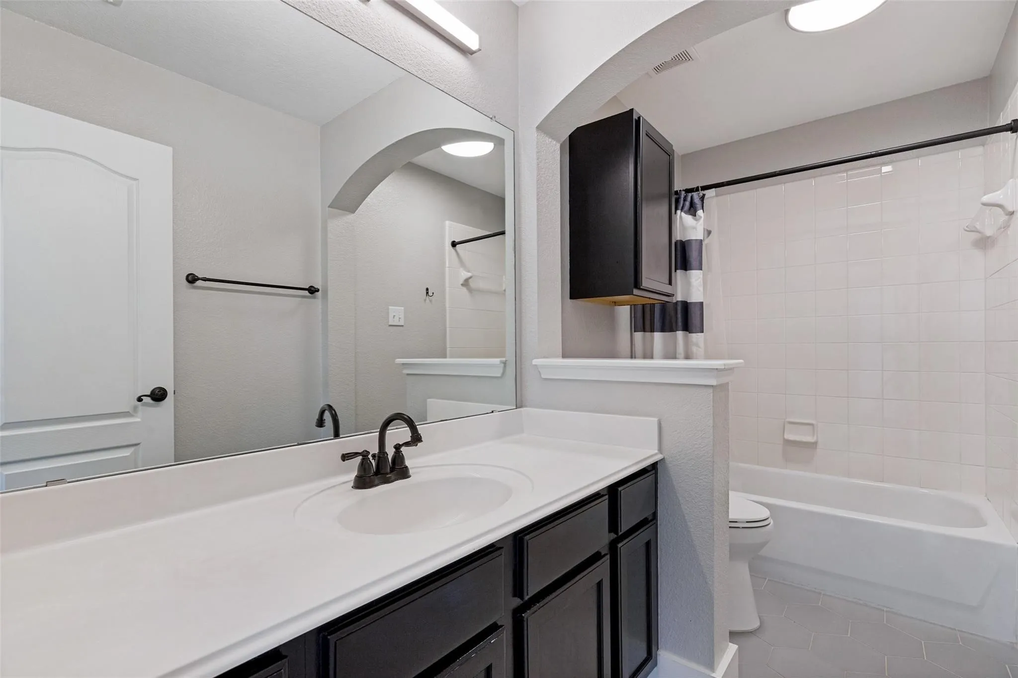 Full vanity with integrated sink and dark cabinetry