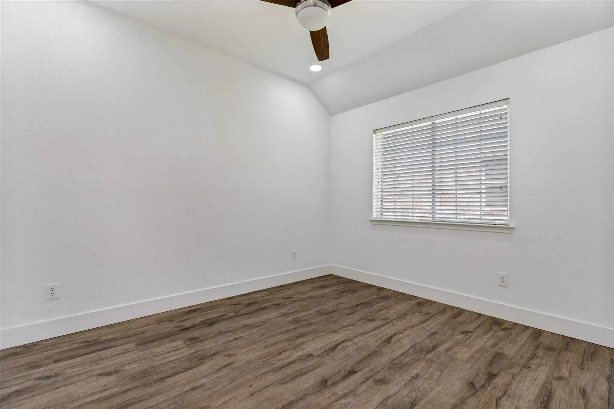 Wood-finish flooring, vaulted ceiling, recessed lighting, and a ceiling fan