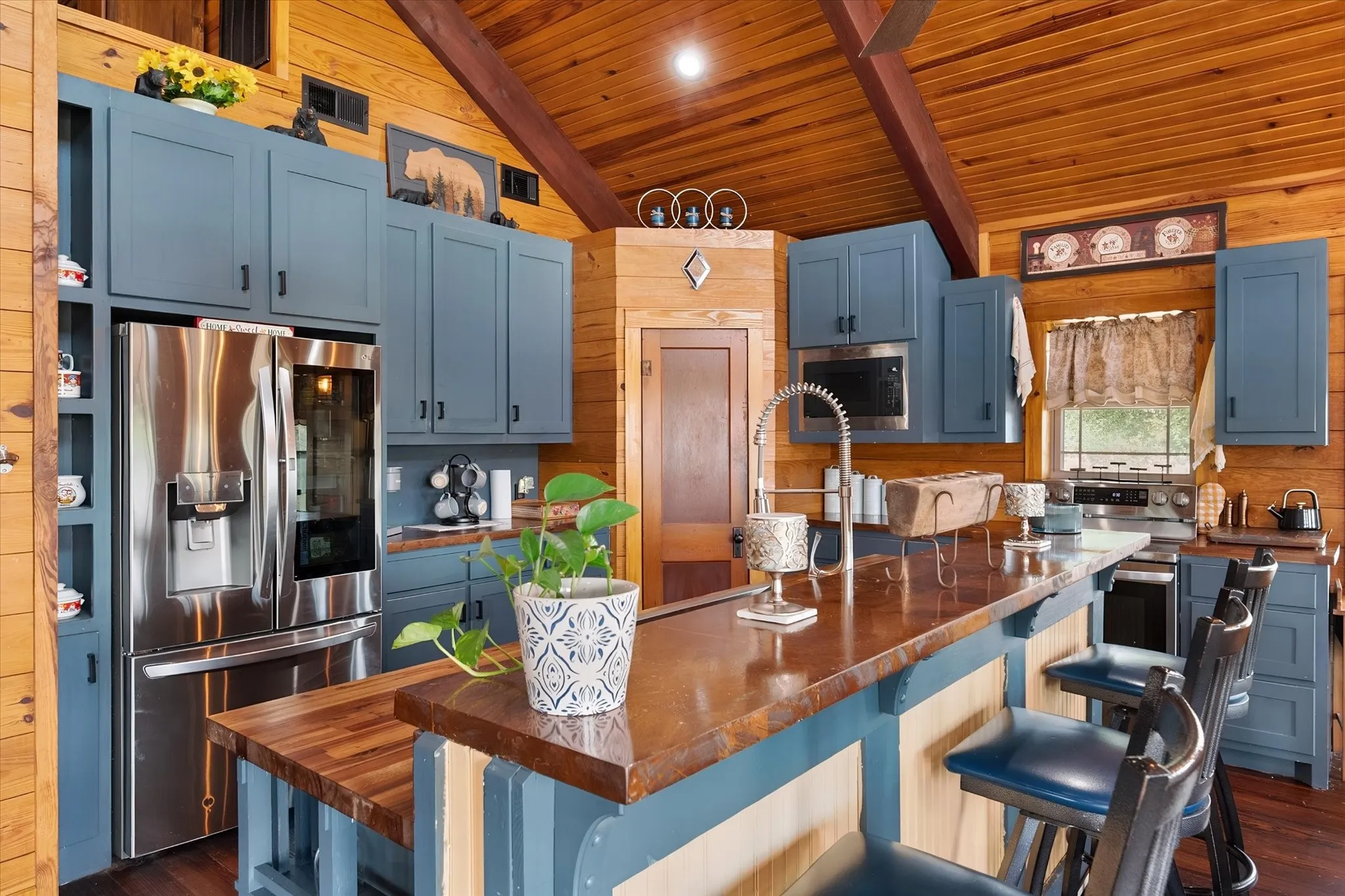 Wood-paneled ceilings with exposed beams, wood-finish flooring, and blue cabinetry