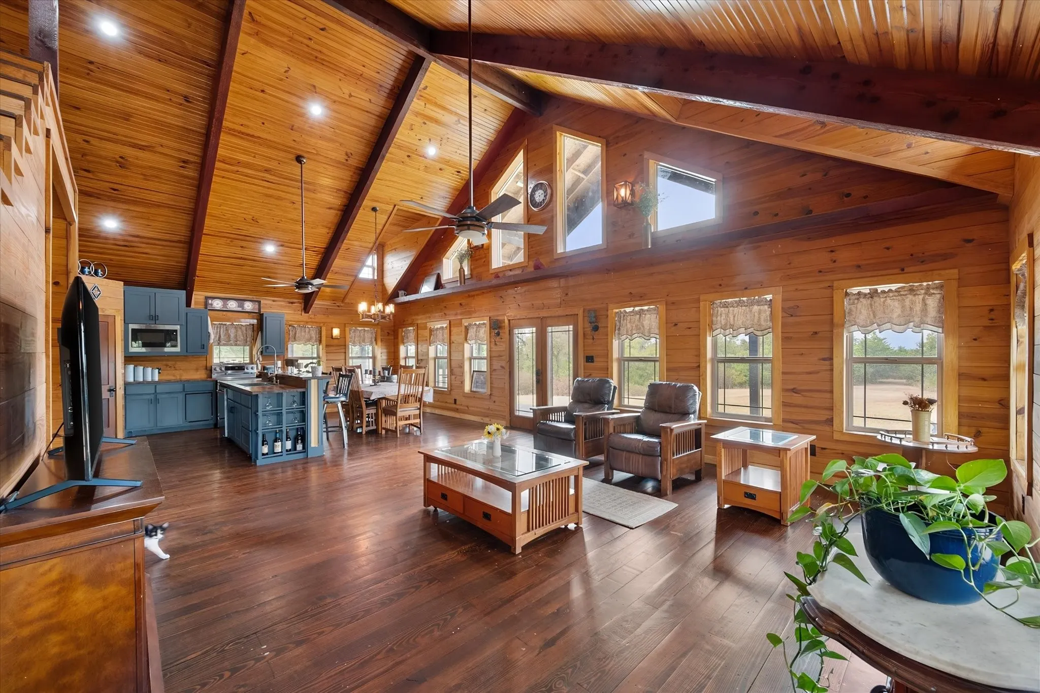 Vaulted wood-paneled ceilings with exposed beams, wood-finish flooring, recessed lighting, and a kitchen island with built-in storage