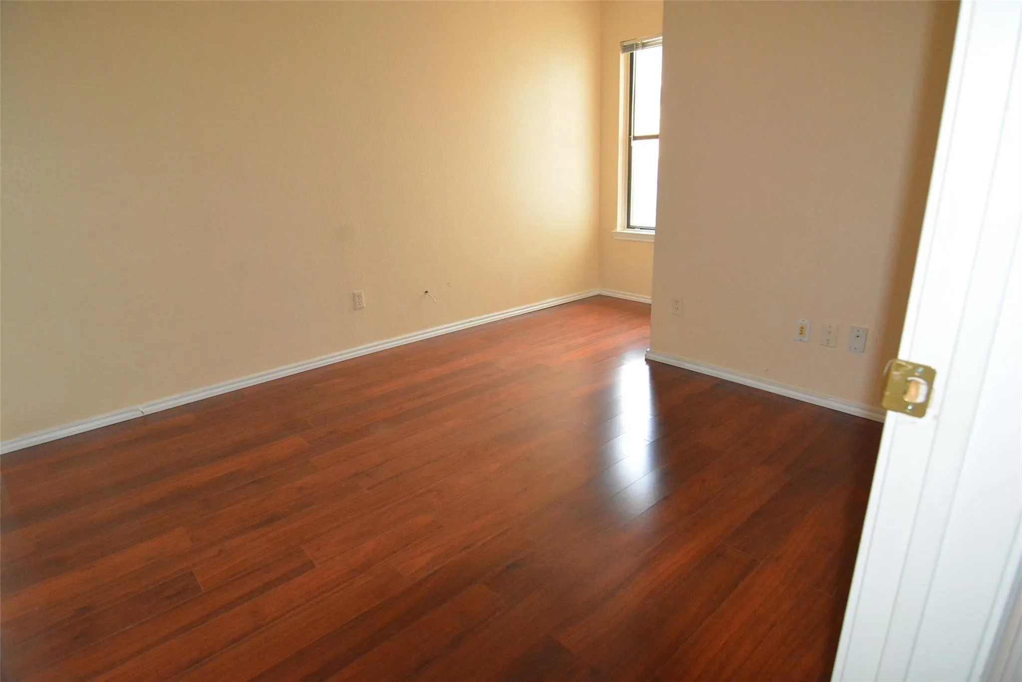 Wood-finish flooring with neutral wall paint and a multi-pane window
