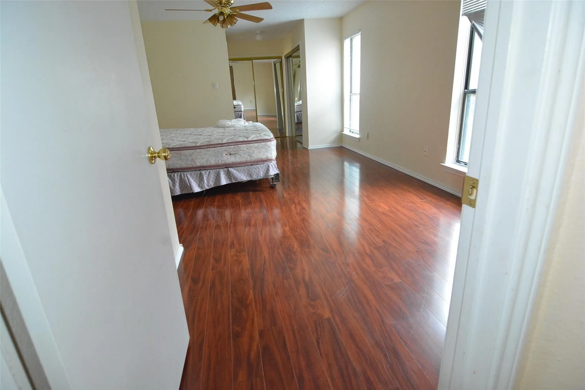 Wood-finish flooring throughout, bright walls, and two windows