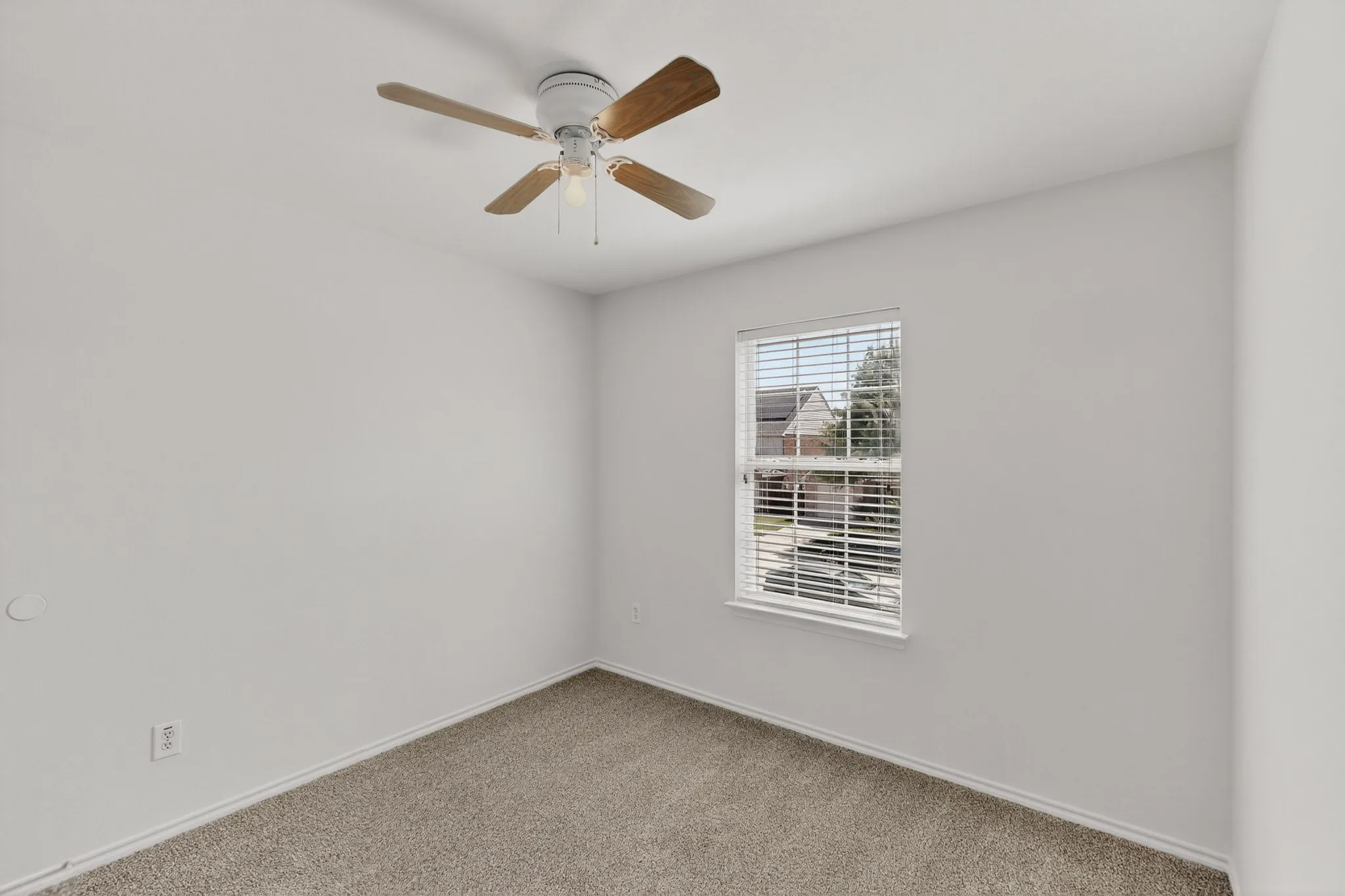 Neutral wall tones with a window featuring horizontal blinds, carpeted flooring, and a ceiling fan with light fixture
