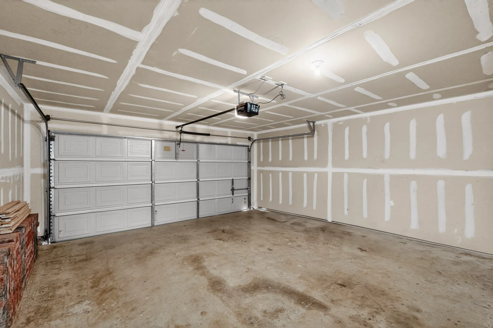 Attached garage with concrete flooring, automatic garage door opener, and overhead lighting
