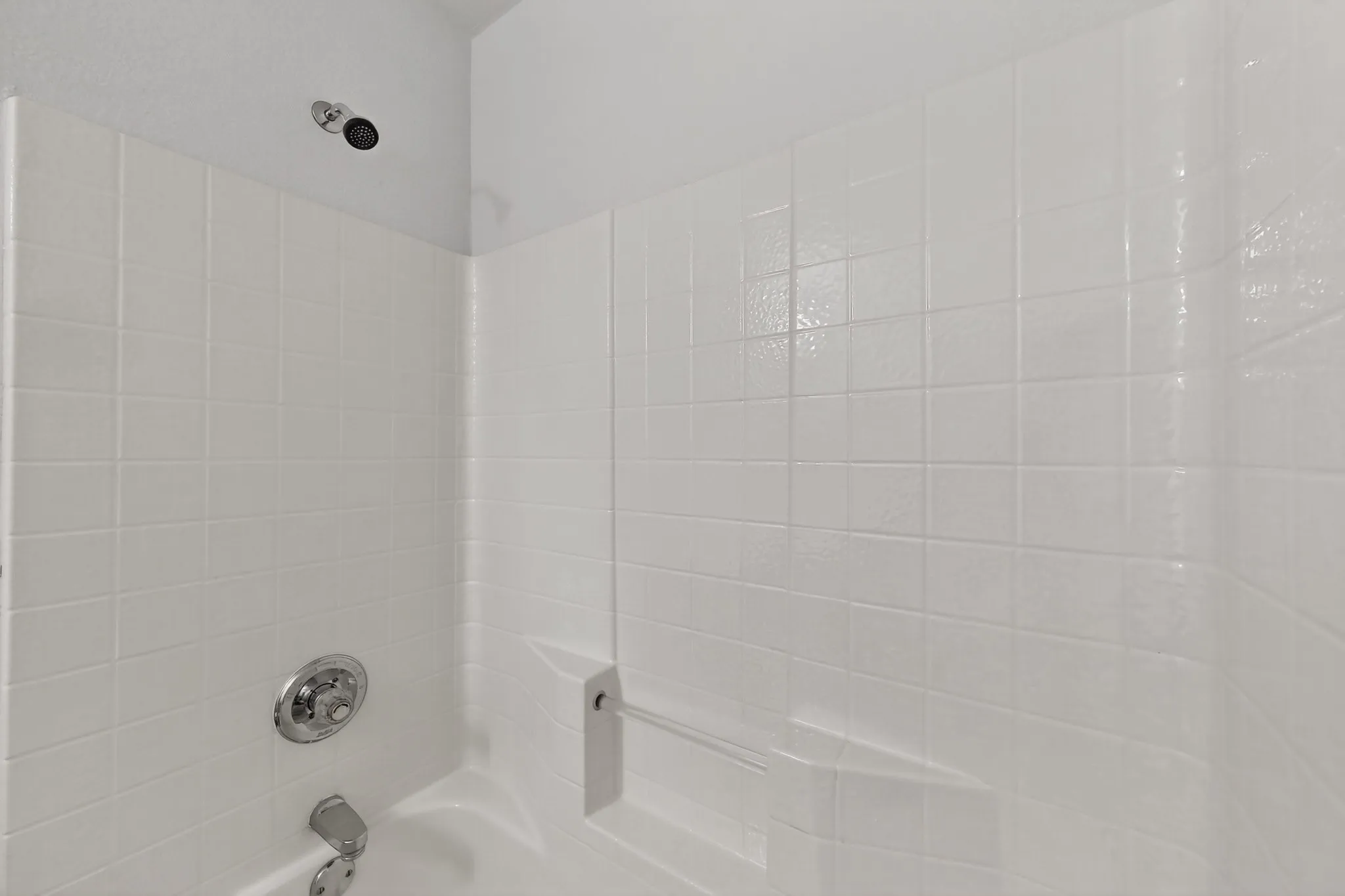 2nd floor Bathroom w Tub and shower combination with white tile surround, chrome fixtures, and built-in grab bar