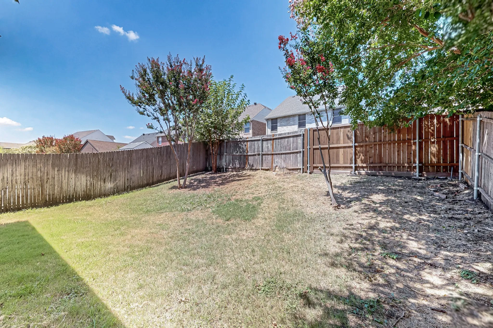 Expansive fenced backyard featuring mature trees