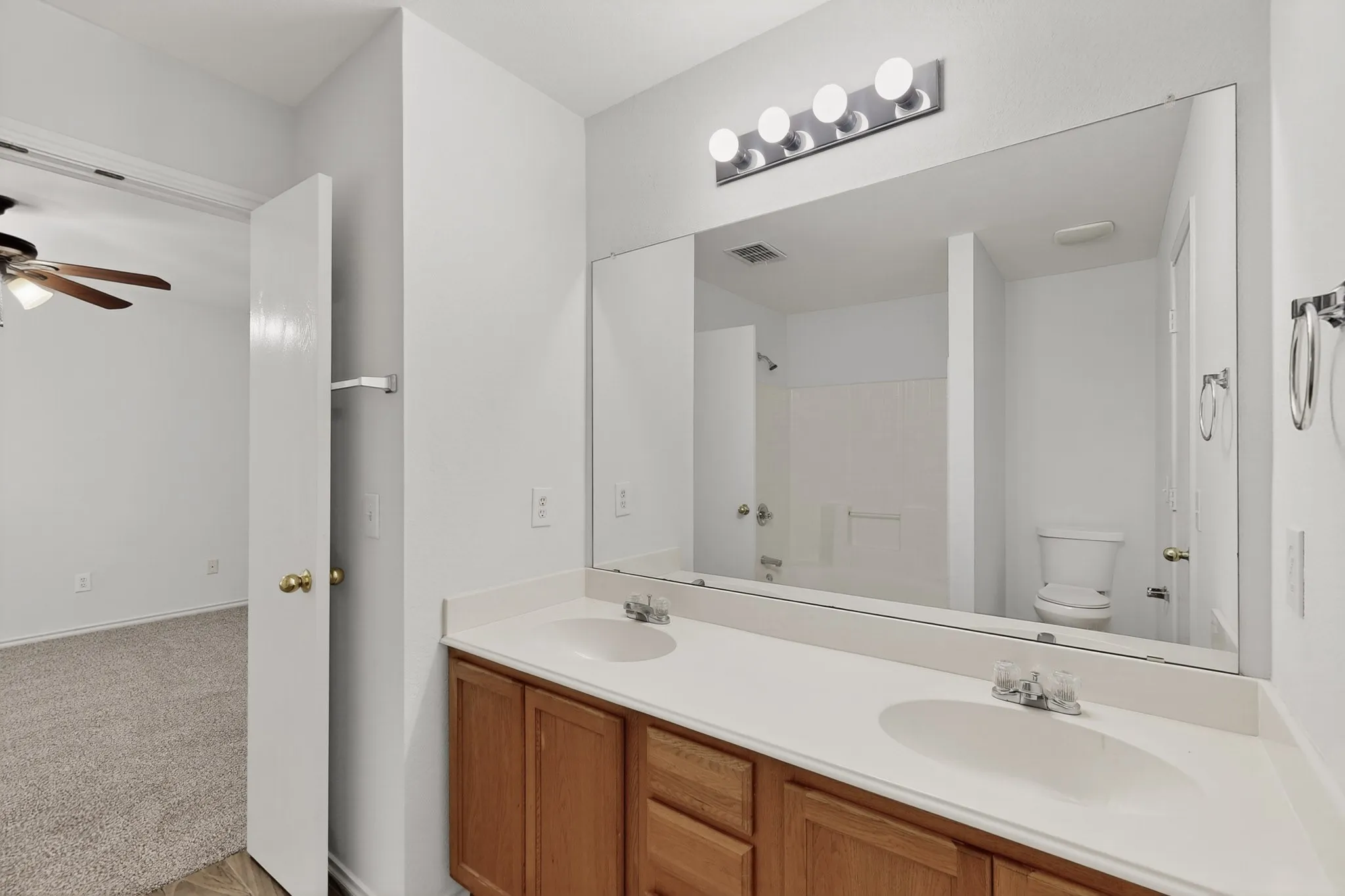 2nd Floor w Dual sink vanity with wood-finish cabinetry and chrome fixtures