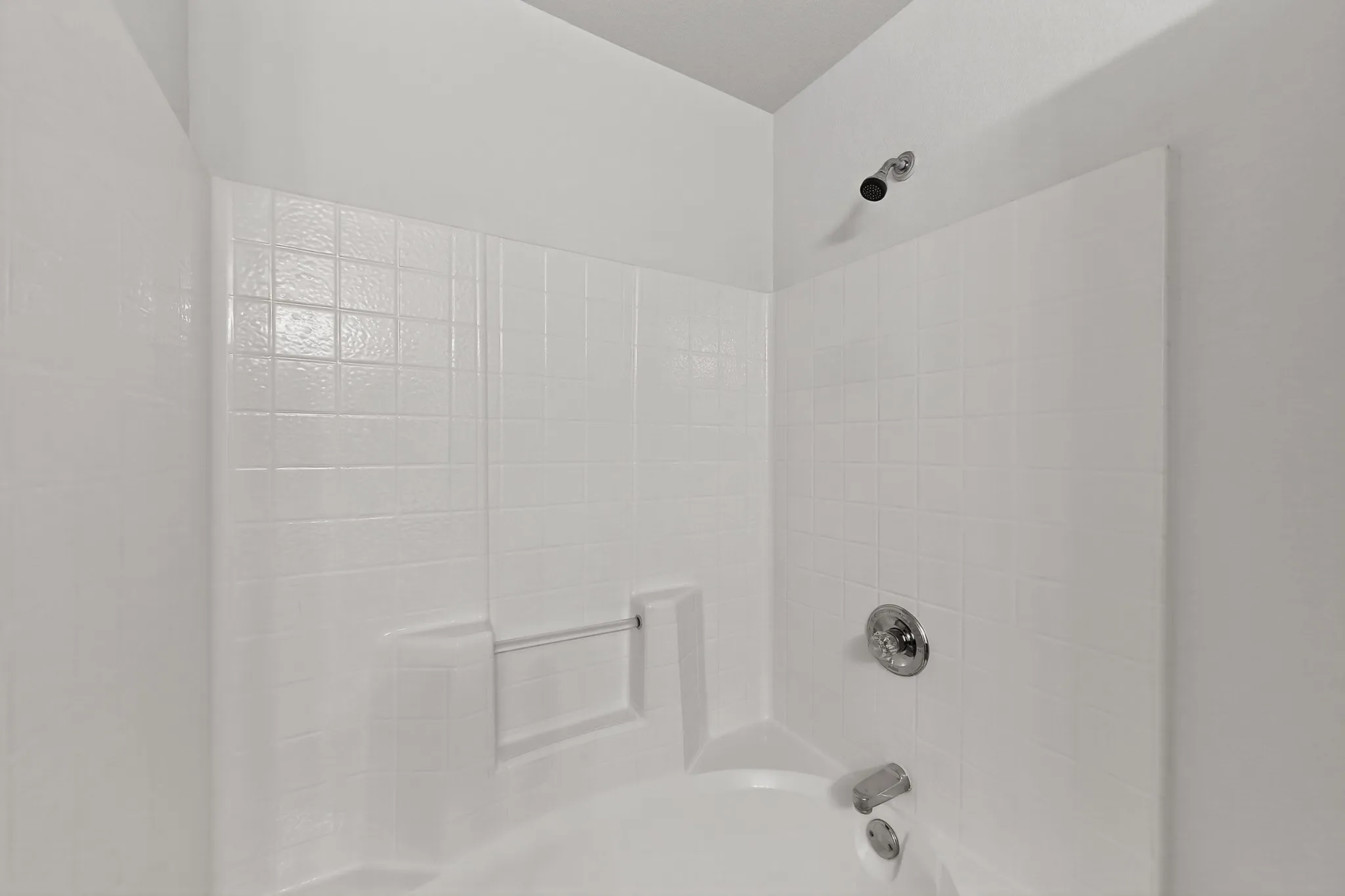 2nd Floor Bath and shower combination with white tile surround, chrome fixtures, and built-in soap dish