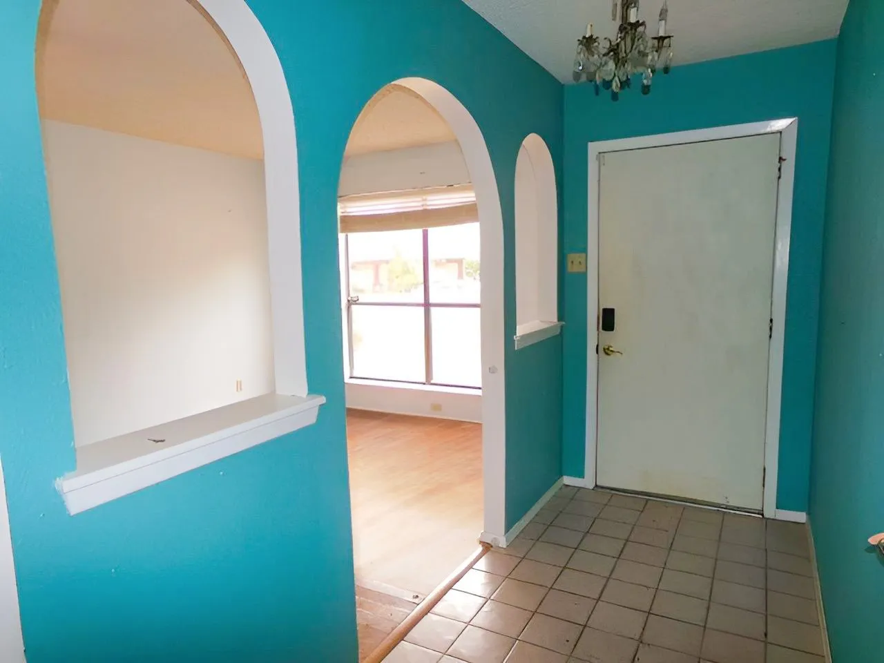 Arched wall openings, decorative niches, and a crystal chandelier