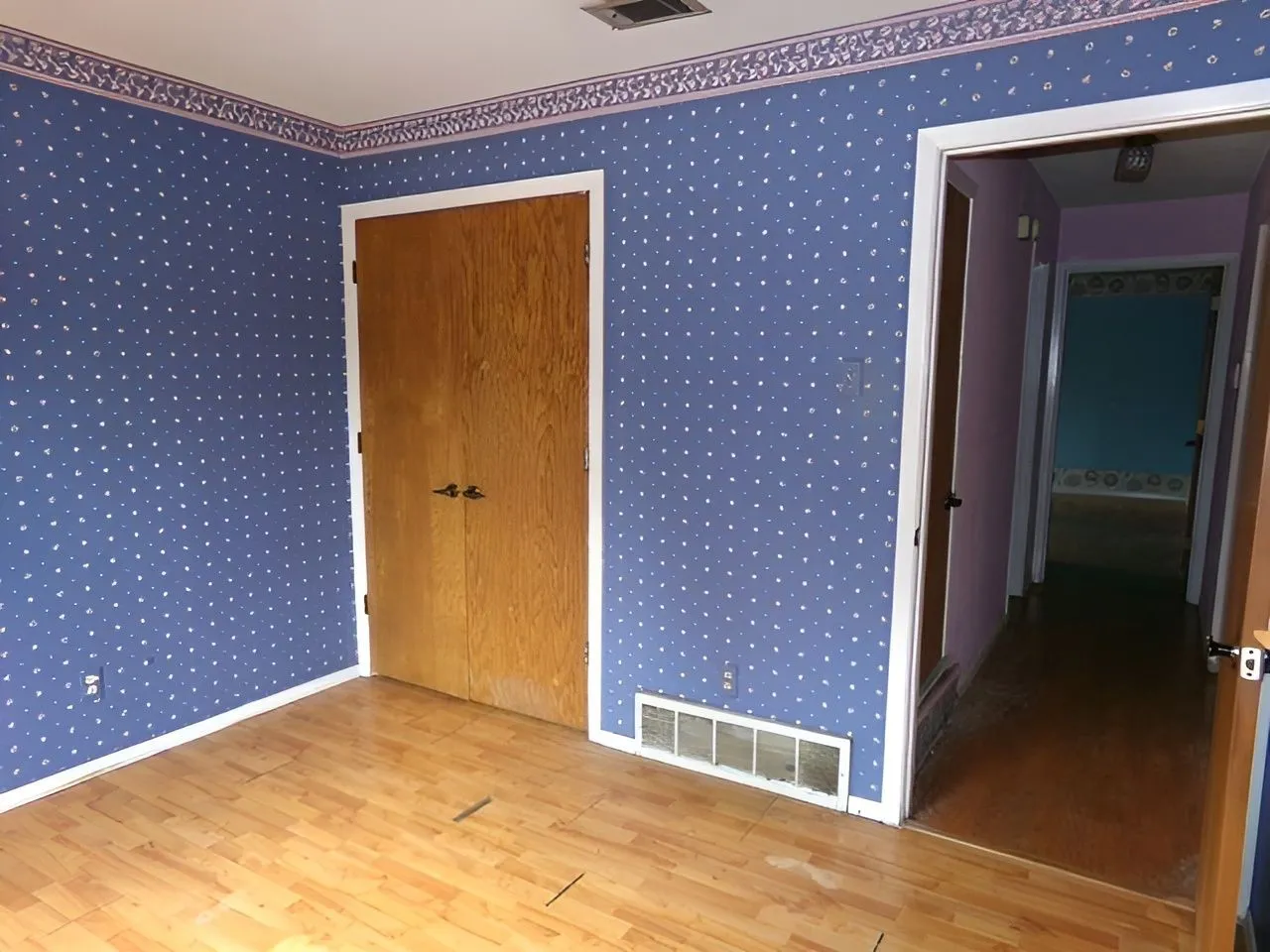 Wood-finish flooring with a light tone, complemented by white baseboards
