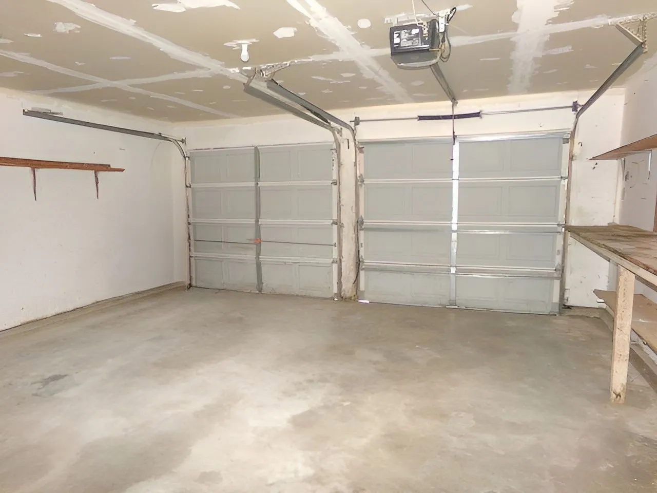 Concrete flooring with two garage doors and an automatic opener