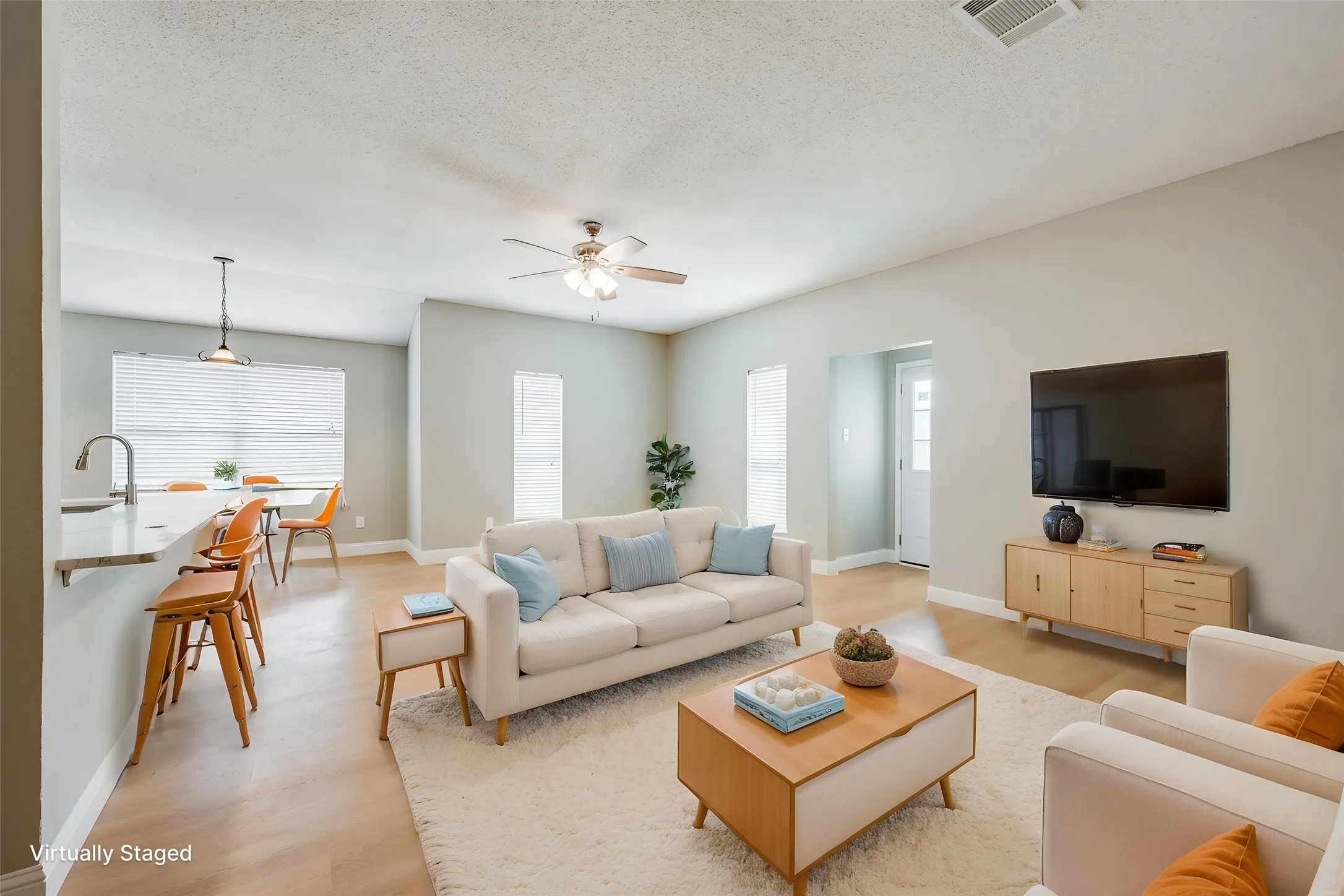 Wood-finish flooring throughout, light-toned walls, and a ceiling fan with integrated lighting