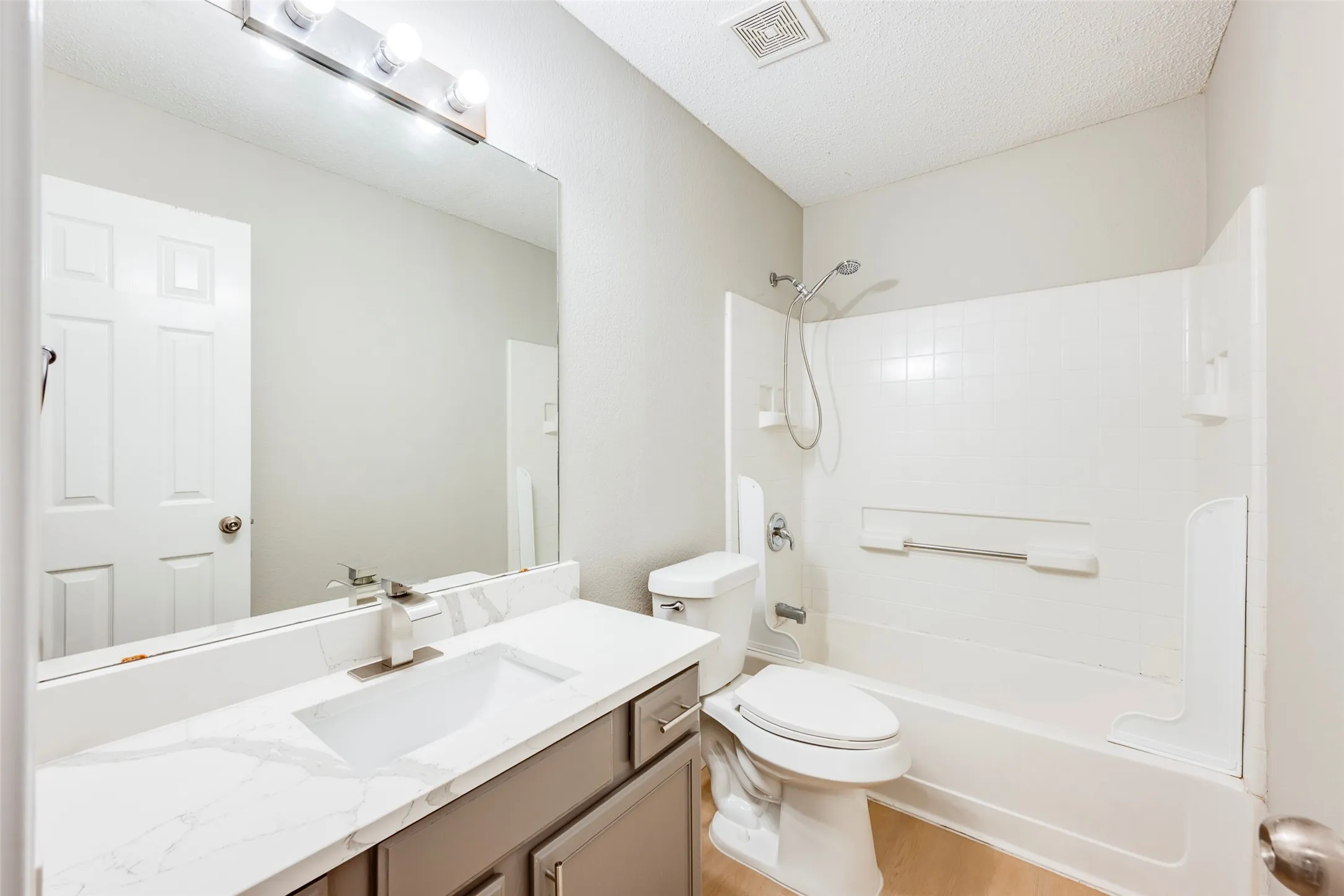 Vanity with integrated sink, white countertop, and brushed nickel faucet