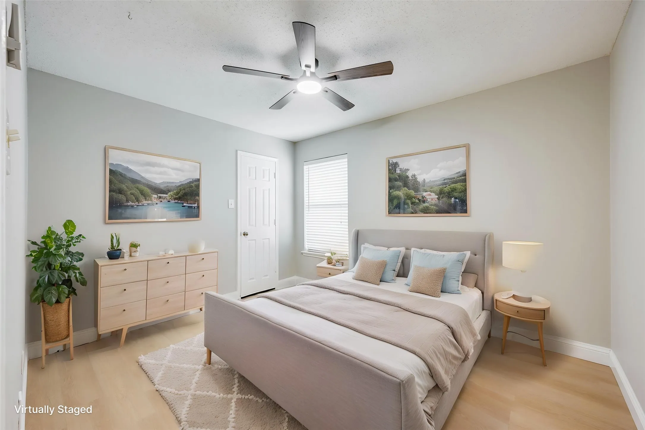 Light-toned wood-finish flooring, ceiling fan with integrated lighting, and window with blinds