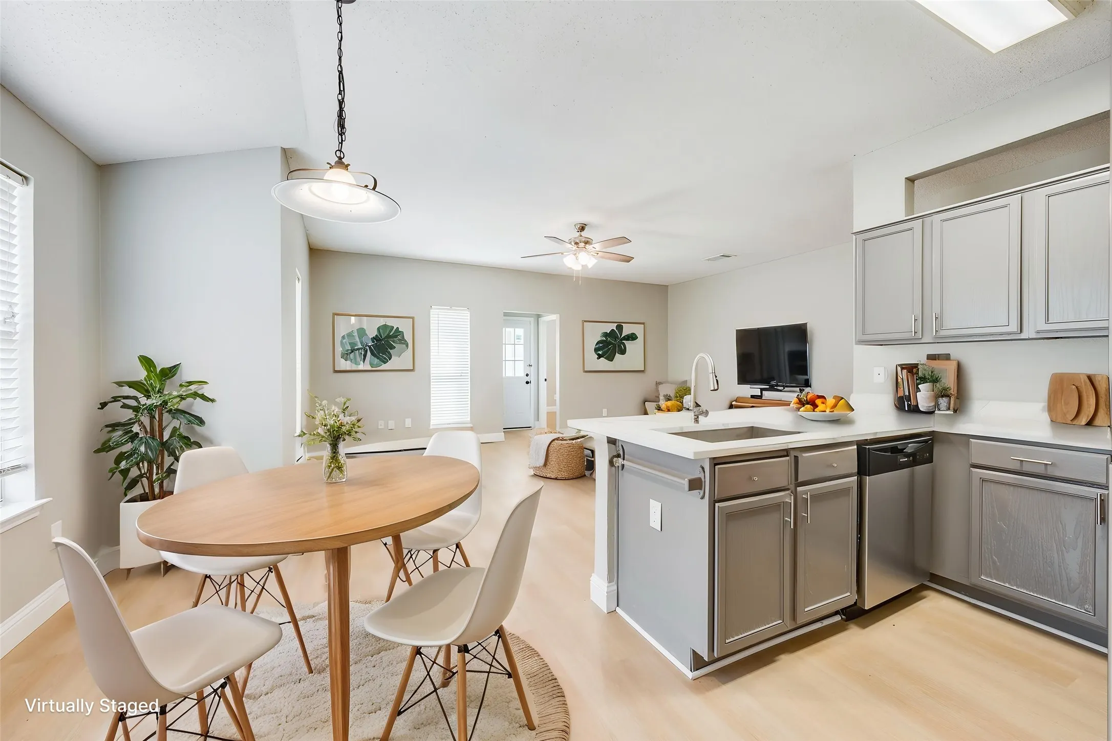Kitchen featuring gray cabinetry, stainless steel appliances, and a central island with an undermount sink