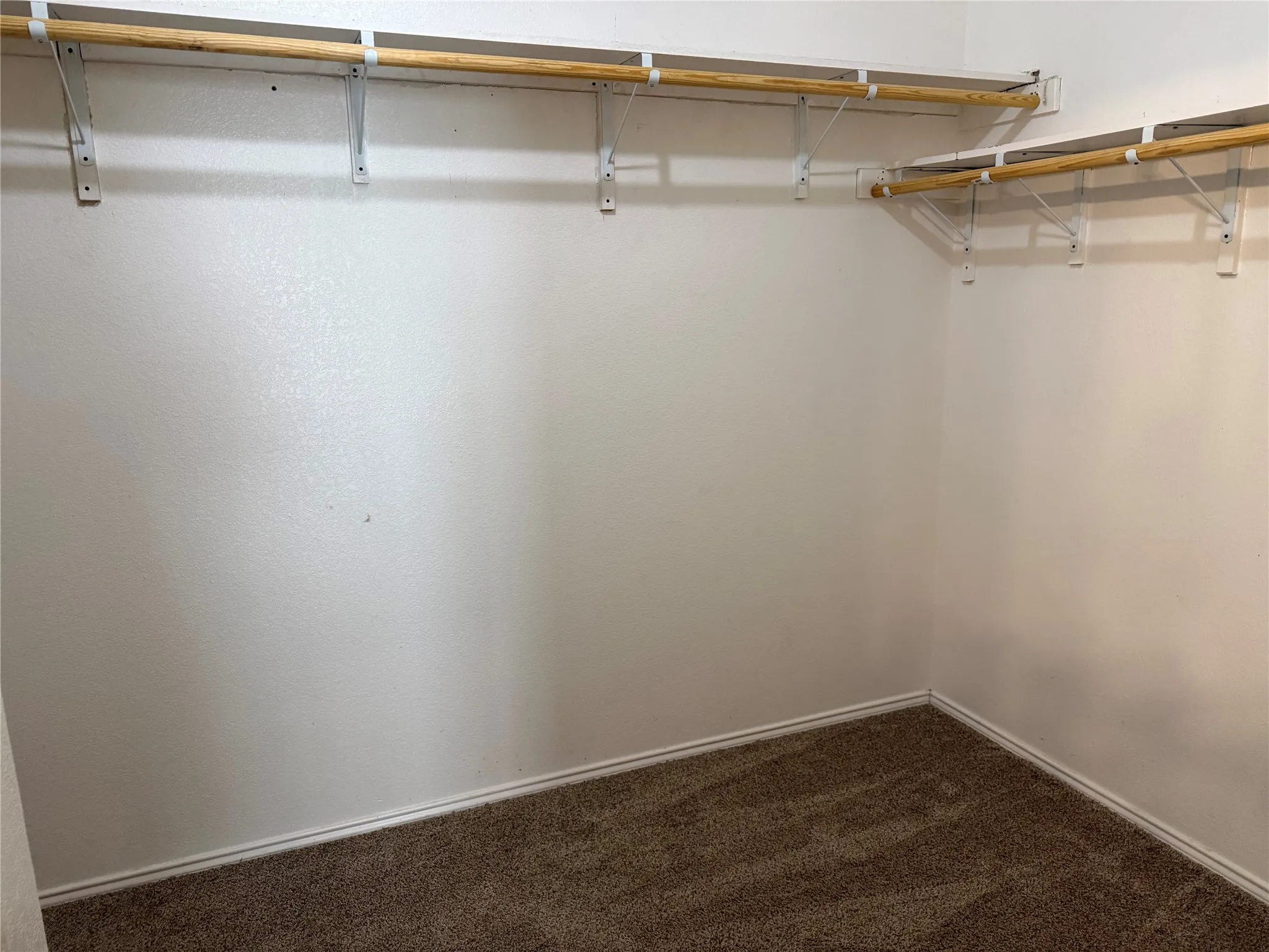 Wood-finish flooring with a large window and blinds