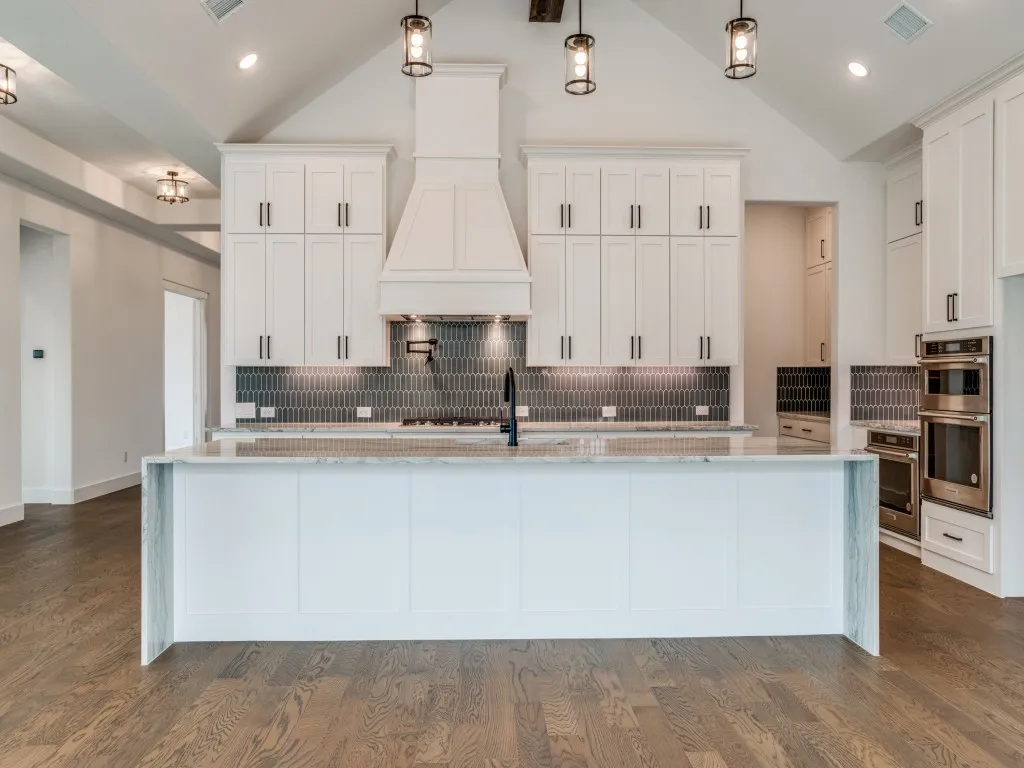 With double stacked cabinets and an oversized, waterfall island, there is no shortage of style, storage or prep space in this dream kitchen!
