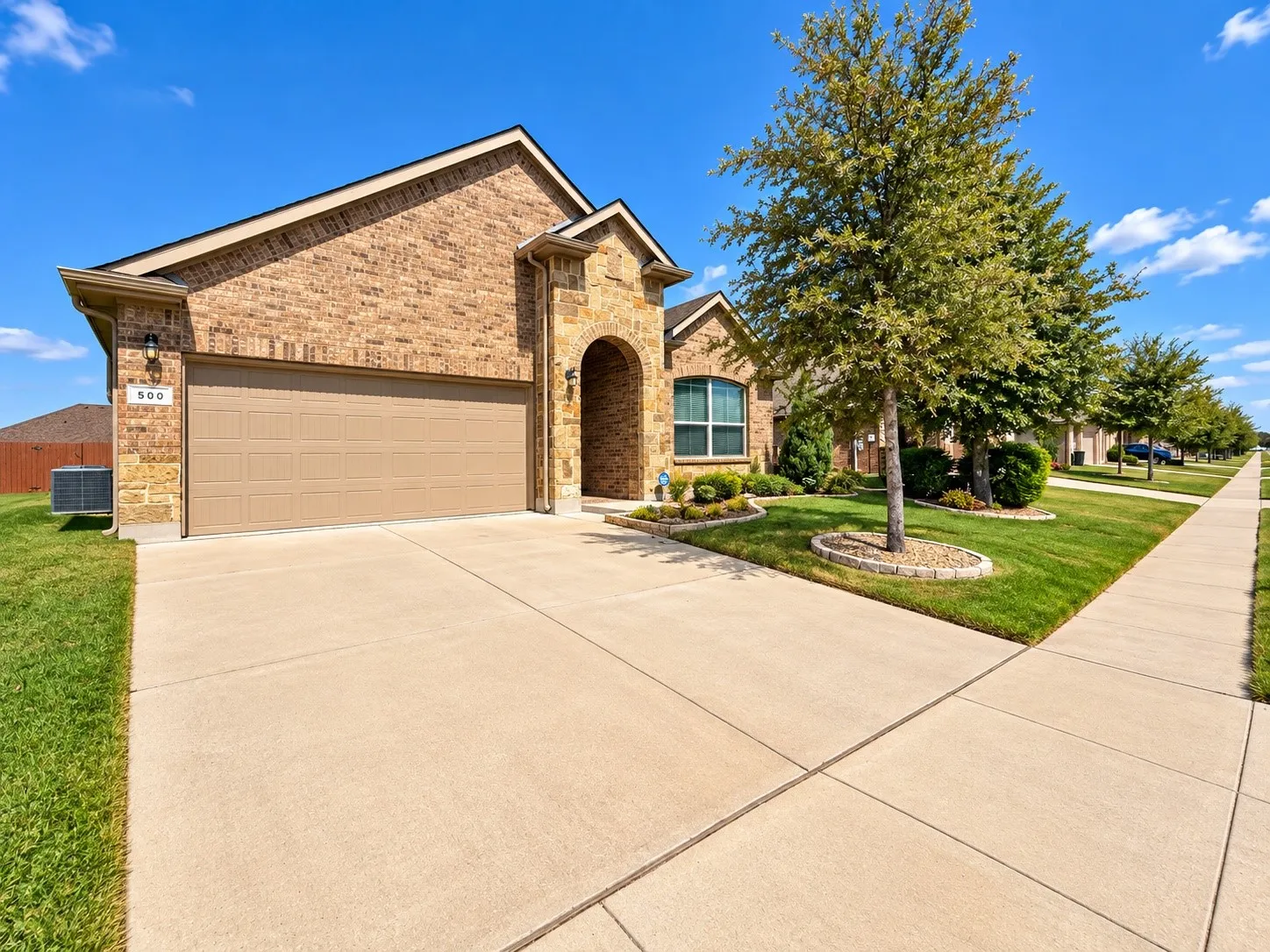 Brick exterior with arched entryway and multi-gabled roofline