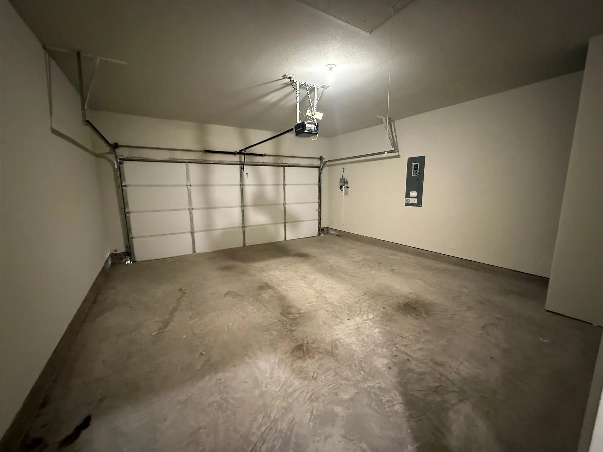 Single-bay garage with overhead door and concrete flooring