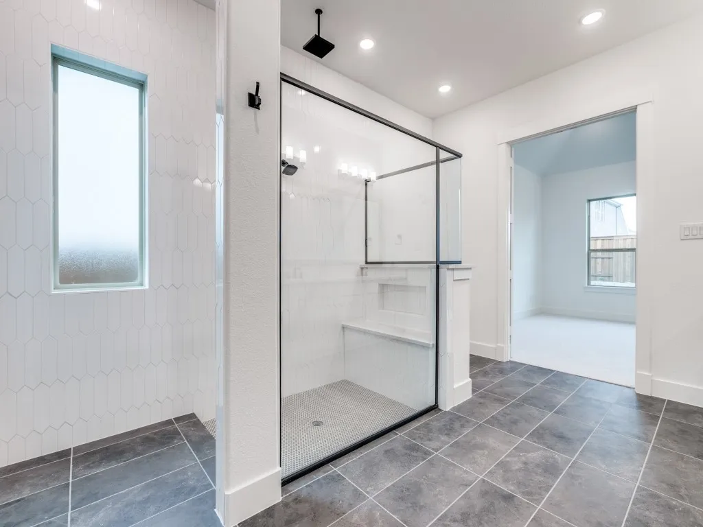 Featuring a spacious walk in shower with built in seat and multiple shower heads, you'll never want to leave this gorgeous owner's bath!