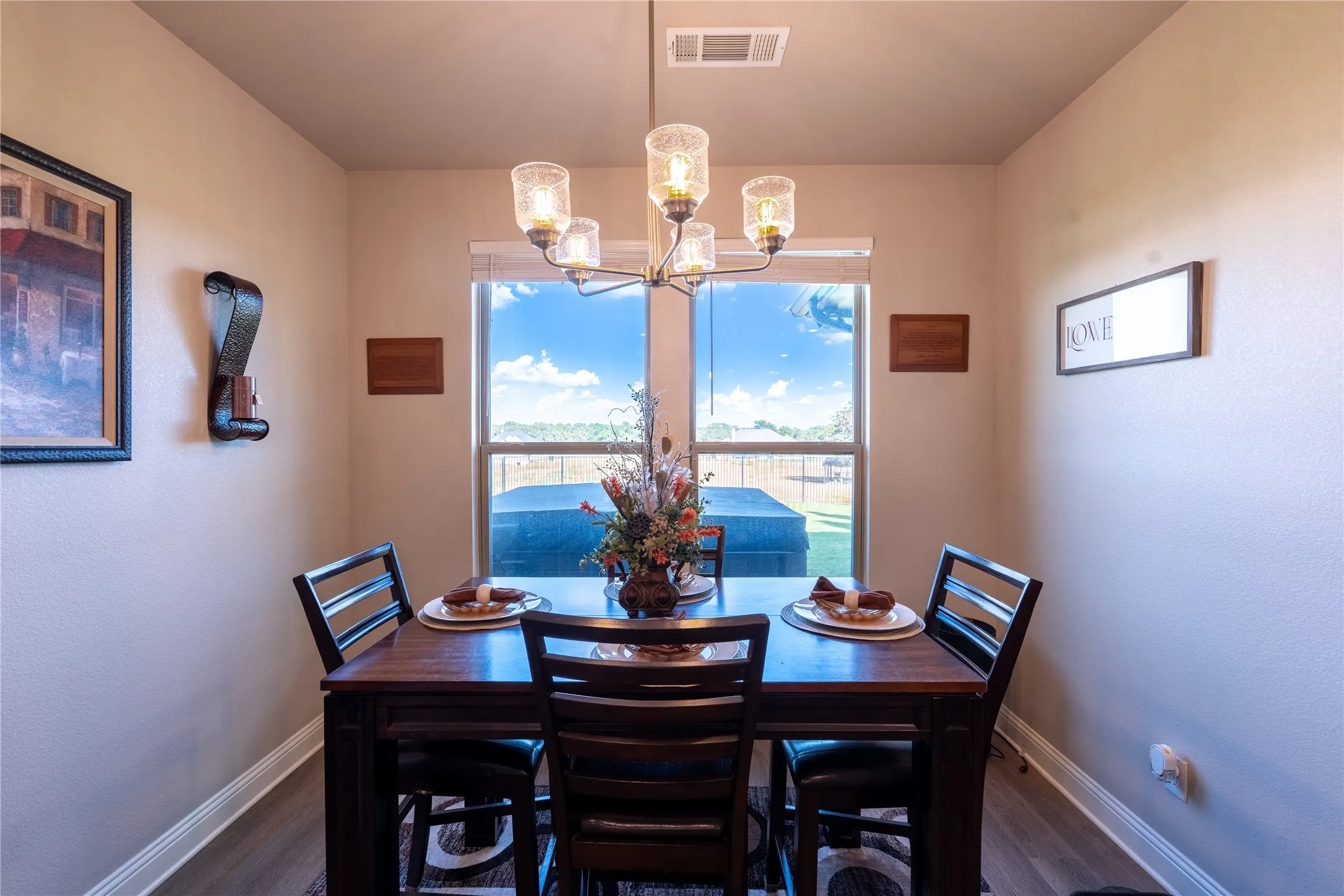 Wood-finish flooring, recessed lighting, and a modern chandelier with glass shades