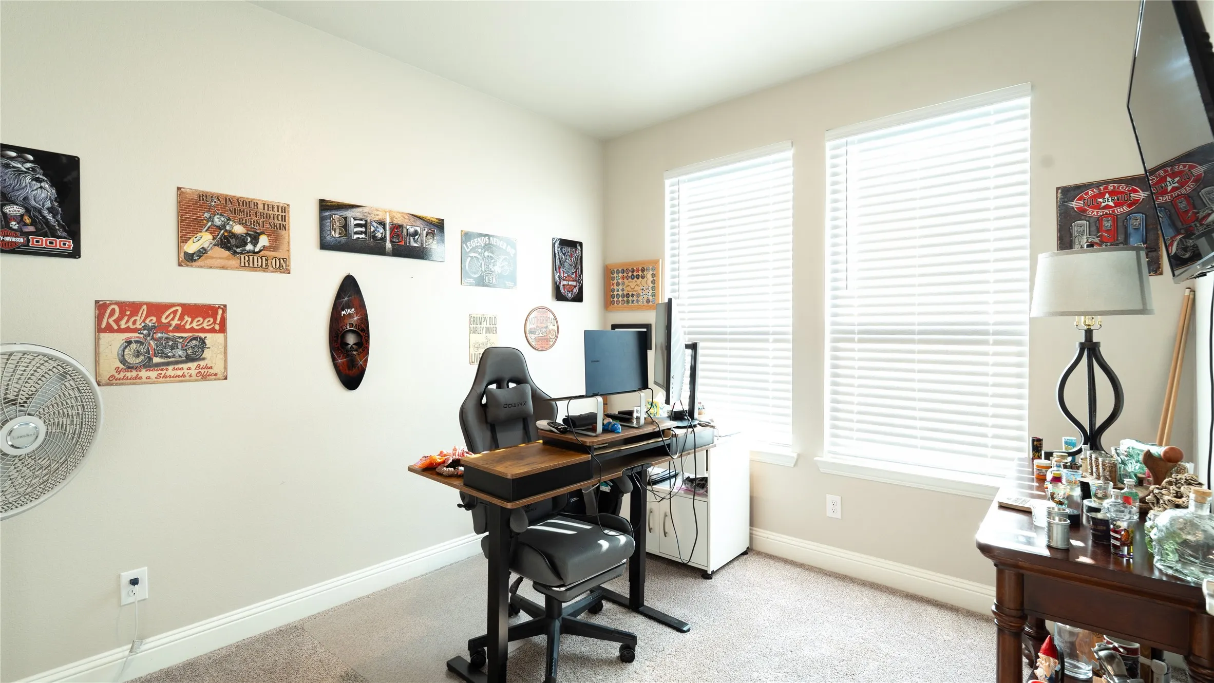 Two windows with blinds, neutral wall paint, and carpeted flooring