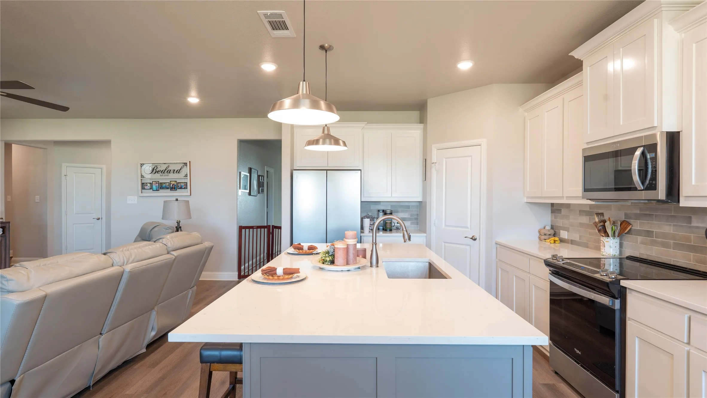 Kitchen island featuring a single-basin sink, pendant lighting, and a light-toned countertop