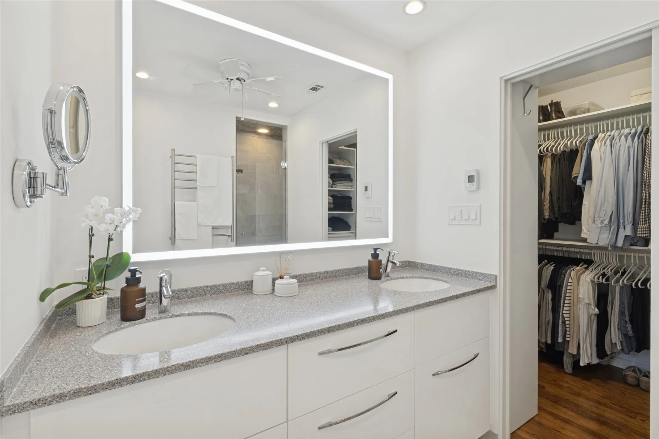 Dual vanity with integrated sinks, granite countertop, and white cabinetry