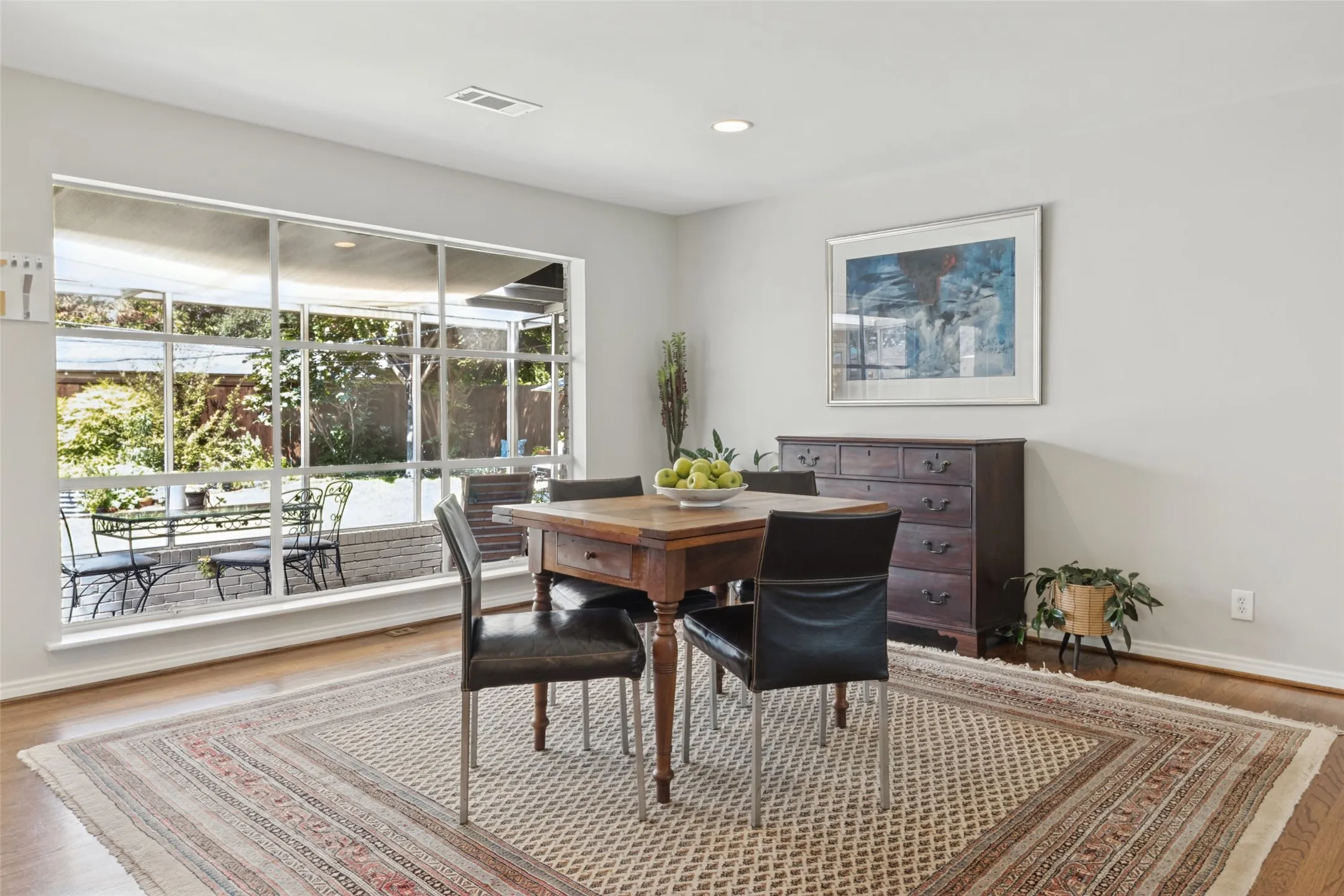 Expansive picture window overlooking a patio, wood-finish flooring, recessed lighting, and light-toned wall finishes