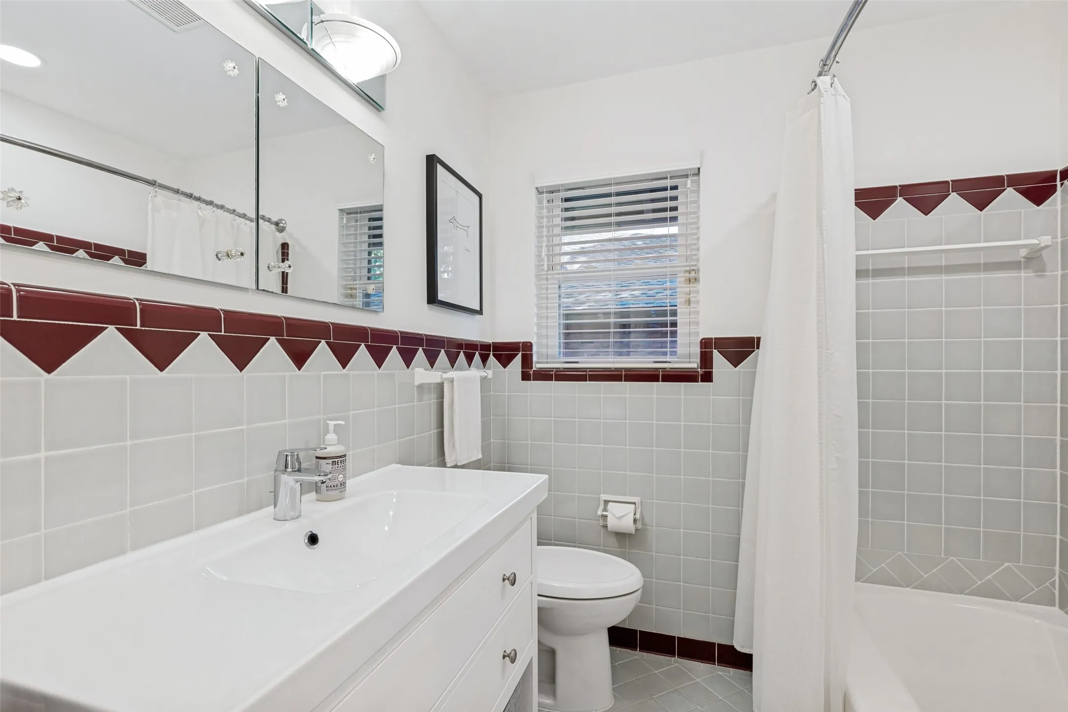Full bathroom featuring a single vanity, integrated sink, mirrored medicine cabinet, and a shower-tub combination