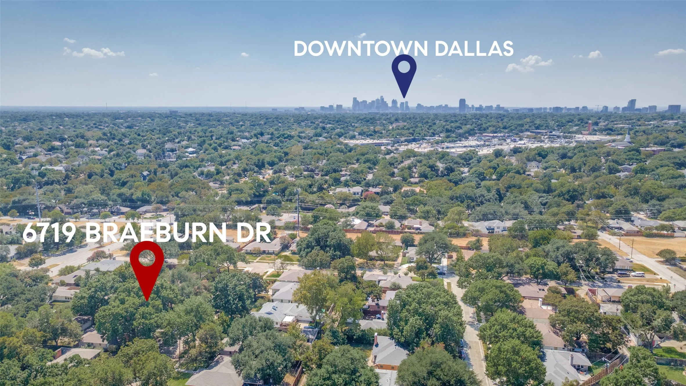 Aerial perspective of a tree-lined residential area with urban skyline in the distance