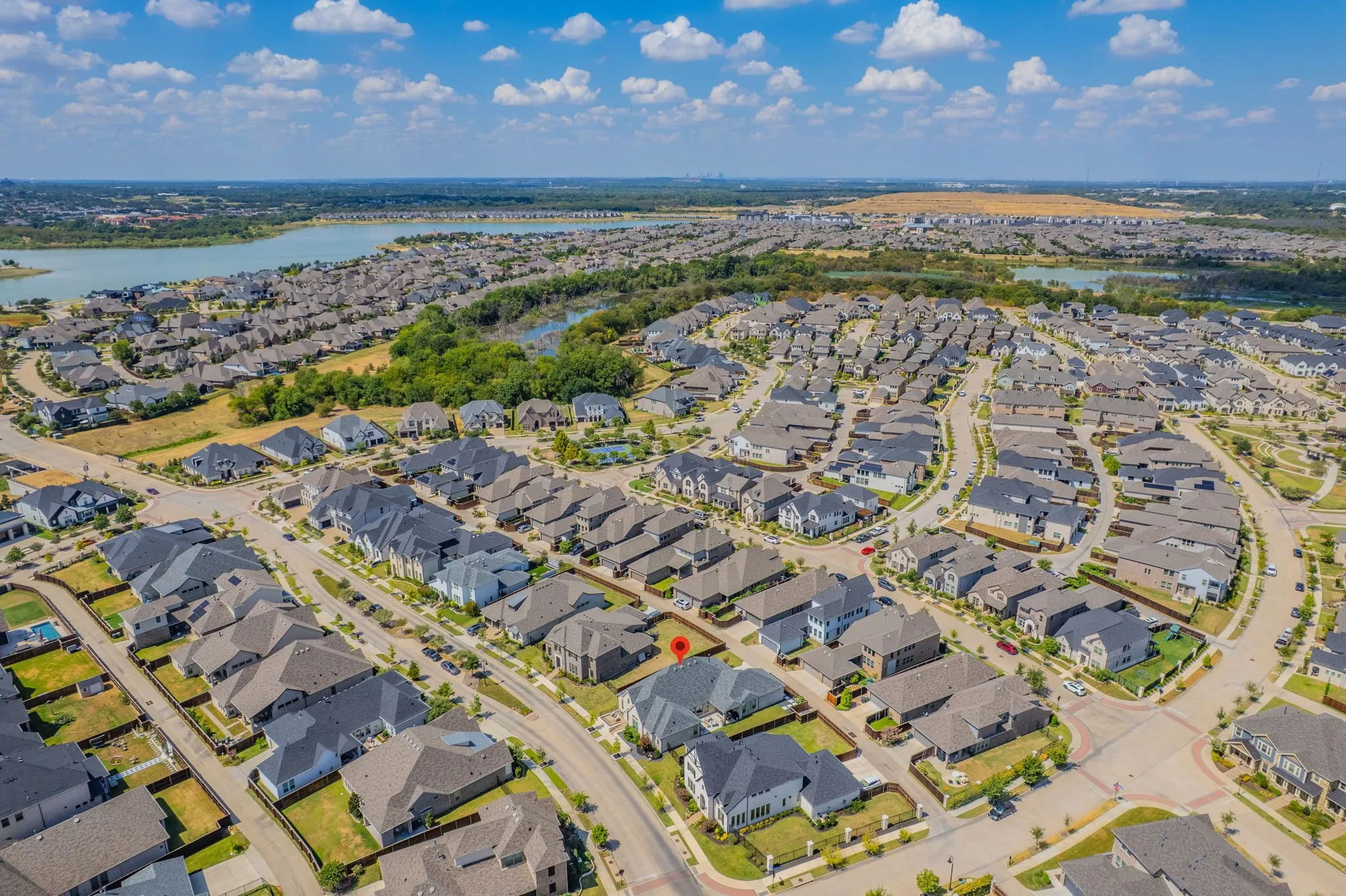 Expansive residential community with established homes, curved streets, and a prominent nearby lake