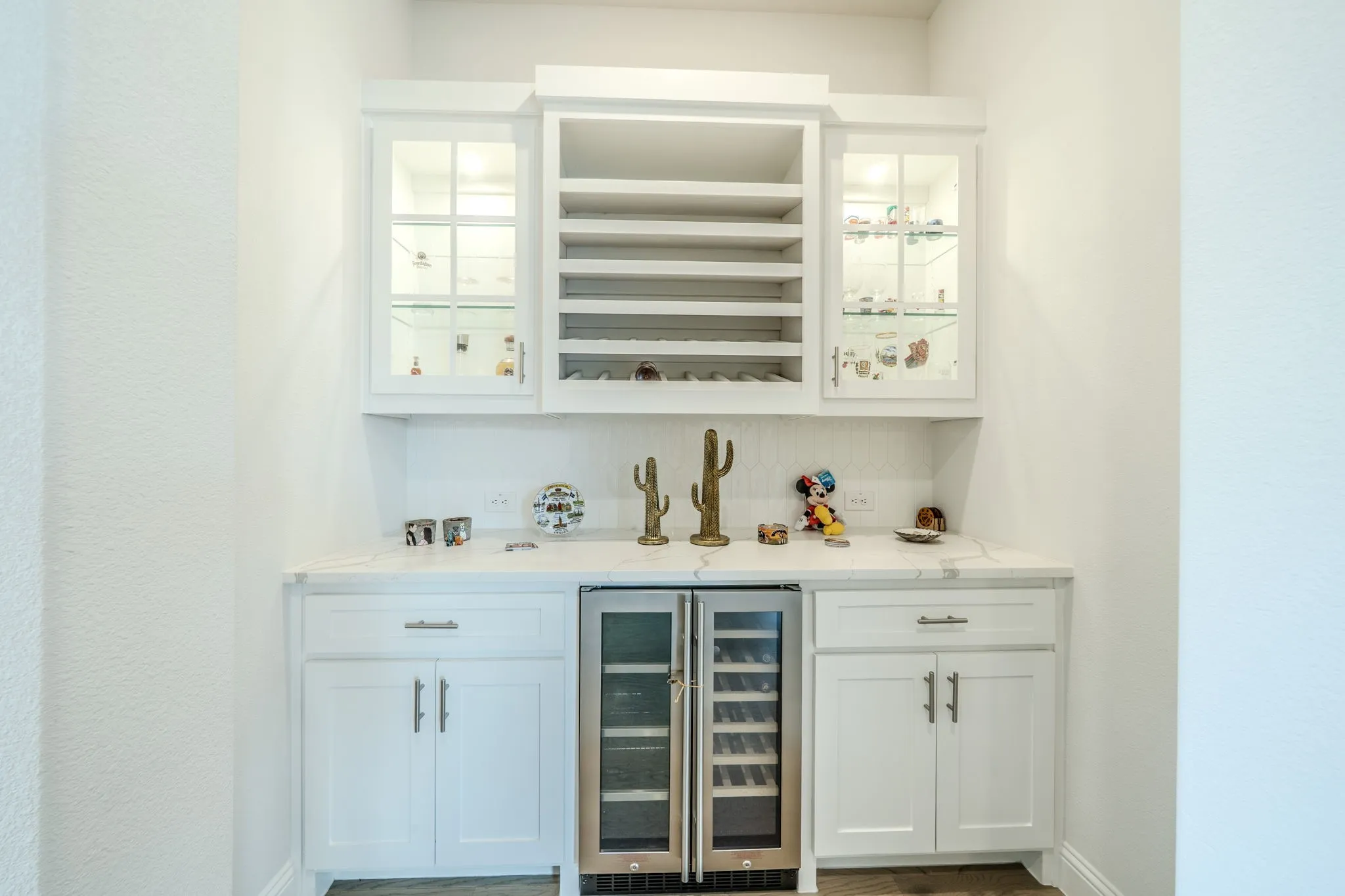 Built-in cabinetry with glass-front uppers, an integrated wine rack, stone countertops, and a built-in beverage refrigerator
