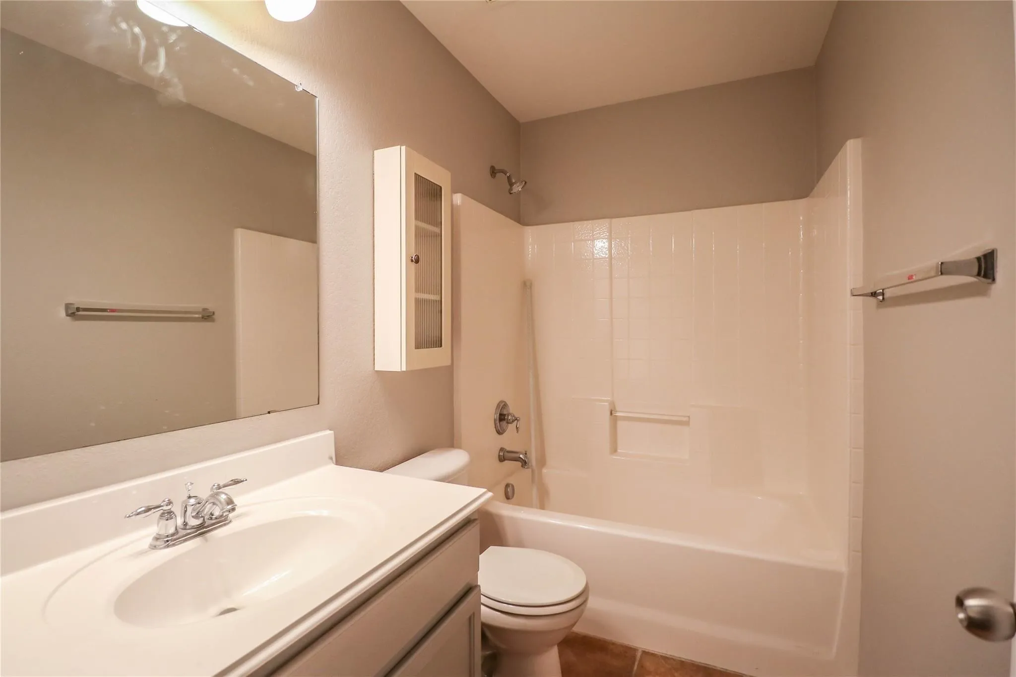 Vanity with integrated sink, chrome faucet, and expansive wall mirror