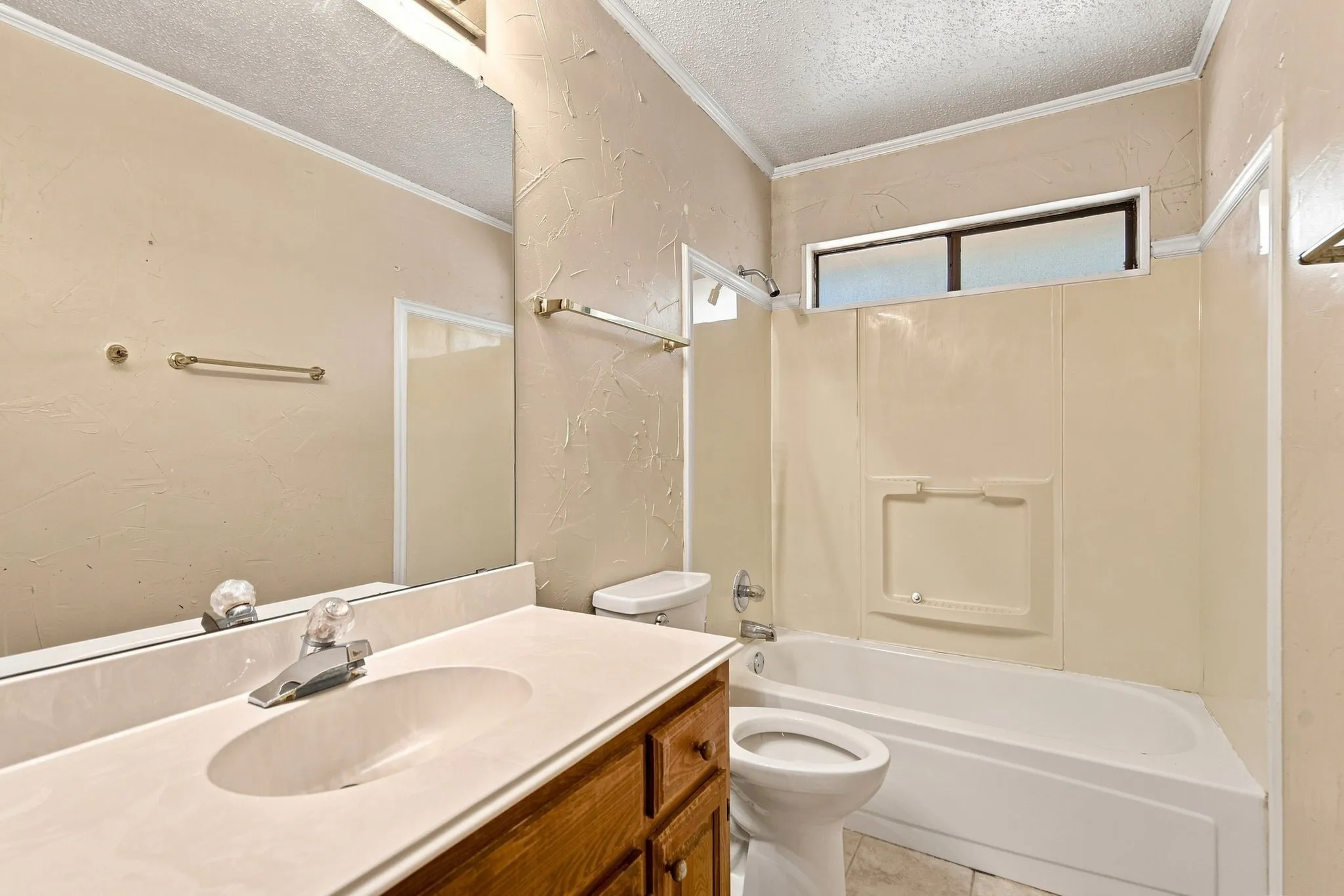 Vanity with wood-finish cabinetry, integrated sink, and chrome-finish faucet
