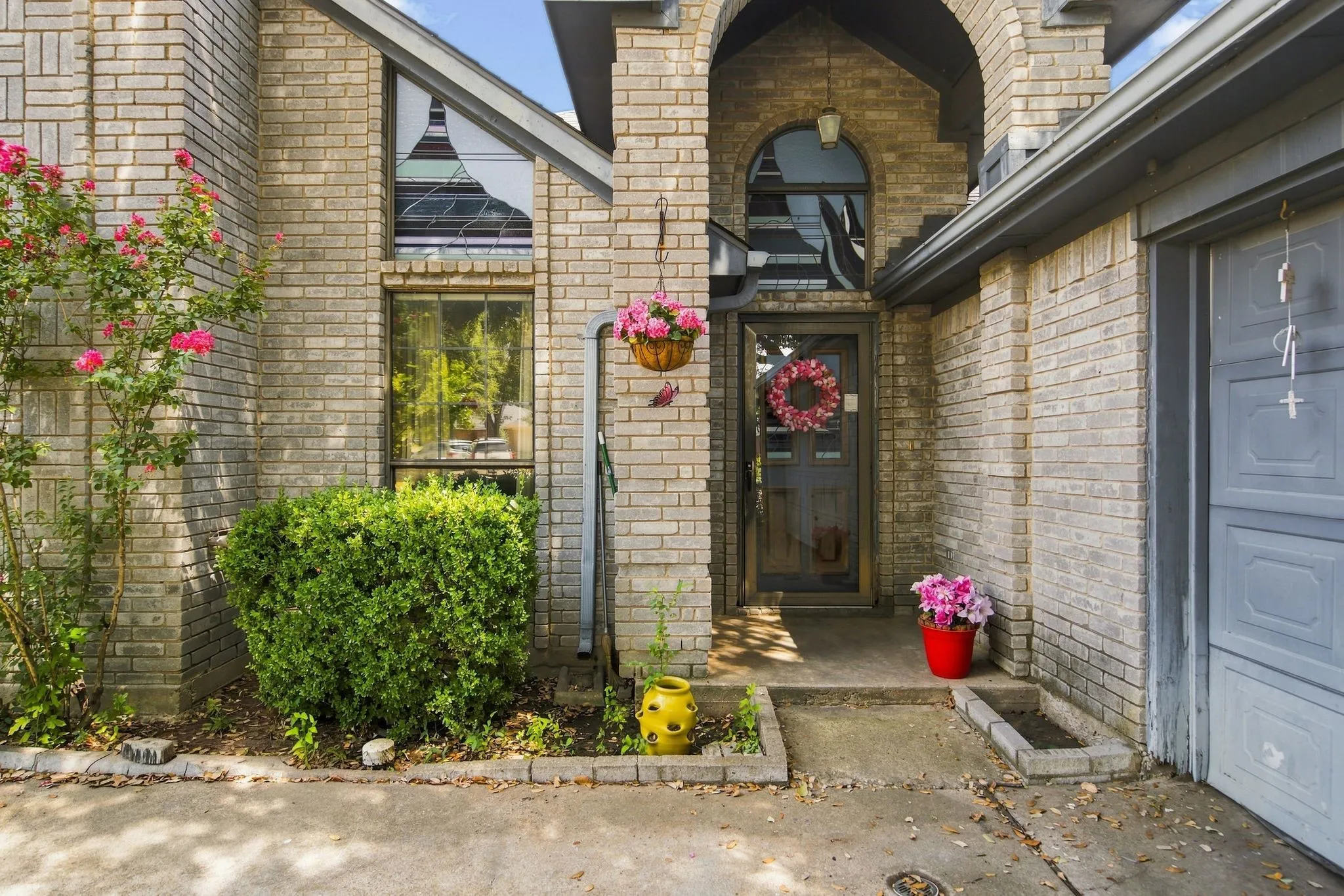 Brick exterior with an arched entry and an integrated garage door
